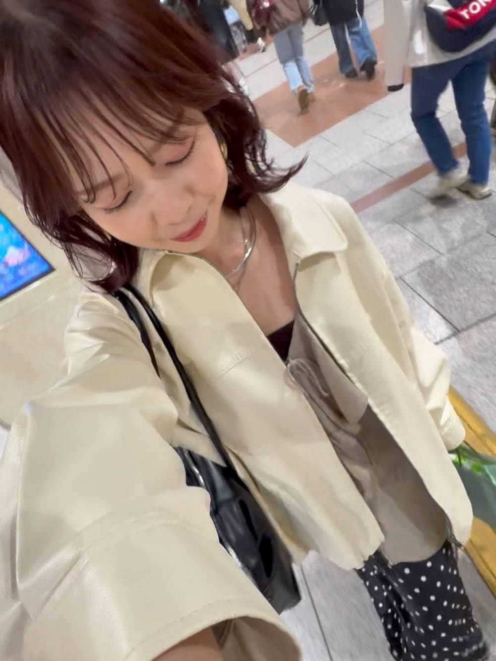 ホワイト系のブルゾン、ブラック系のスカート、ブラック系のボストンバッグを着用したレディースの春コーディネートの3枚目の写真