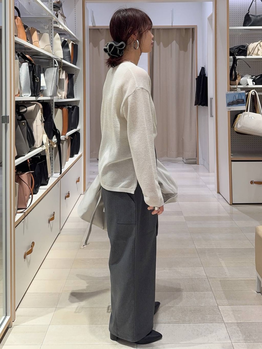 ベージュ系のトレンチコート、ブラック系のトートバッグ、グレー系のその他パンツを着用したレディースの春コーディネートの6枚目の写真