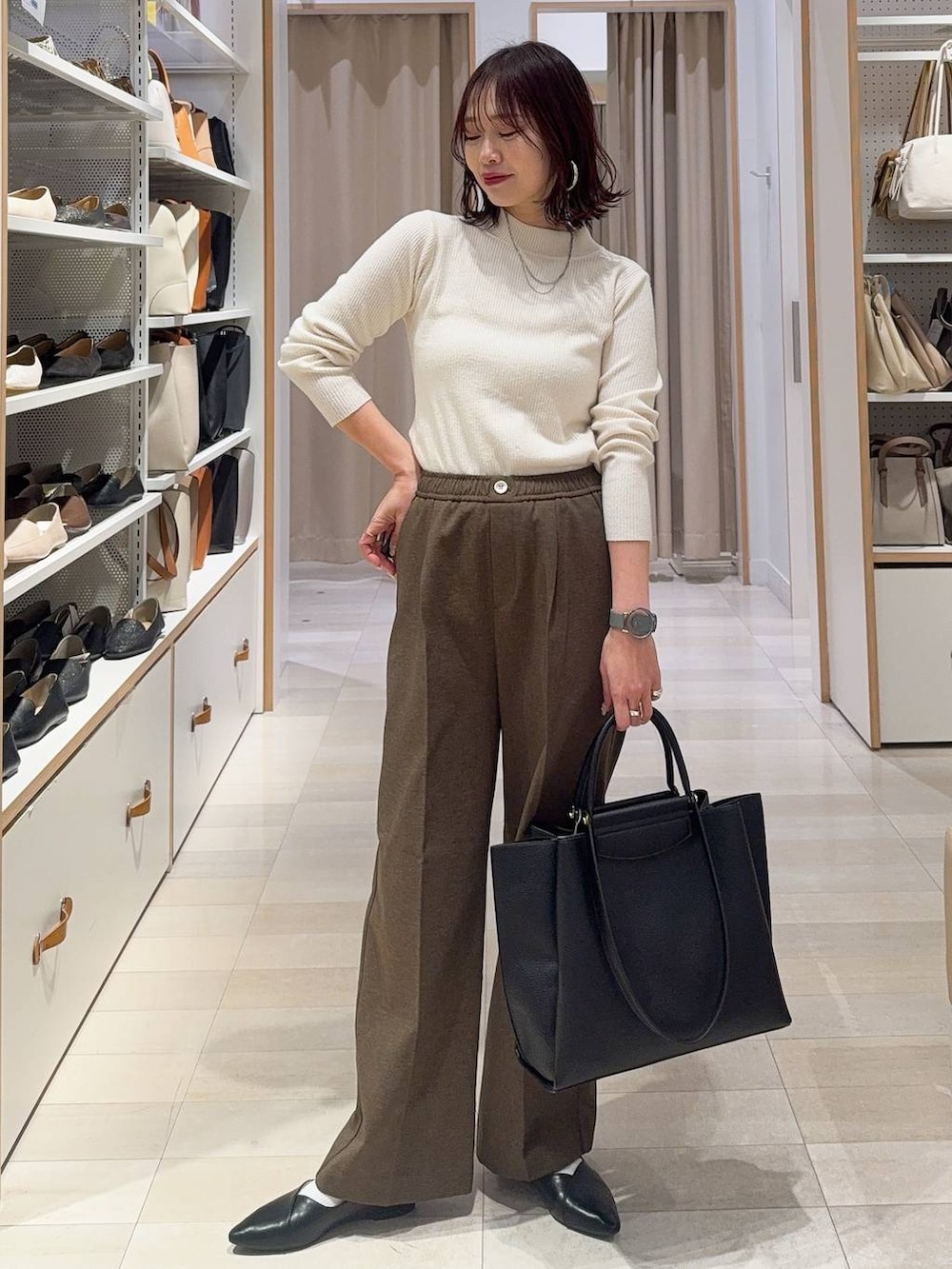 ブラック系のパンプス、ホワイト系のニット/セーター、ブラウン系のその他パンツを着用したレディースの冬コーディネートの3枚目の写真