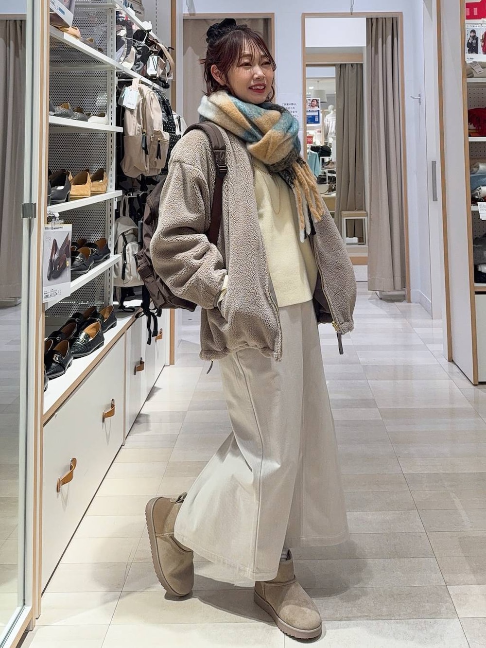 ブラウン系のブルゾン、グレー系のスカート、イエロー系のニット/セーターを着用したレディースの冬コーディネートの2枚目の写真