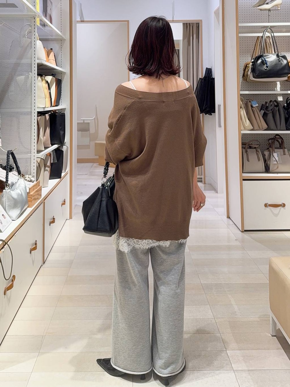 ホワイト系のキャミソール、ブラウン系のニット/セーター、グレー系のスウェットパンツを着用したレディースの冬コーディネートの9枚目の写真