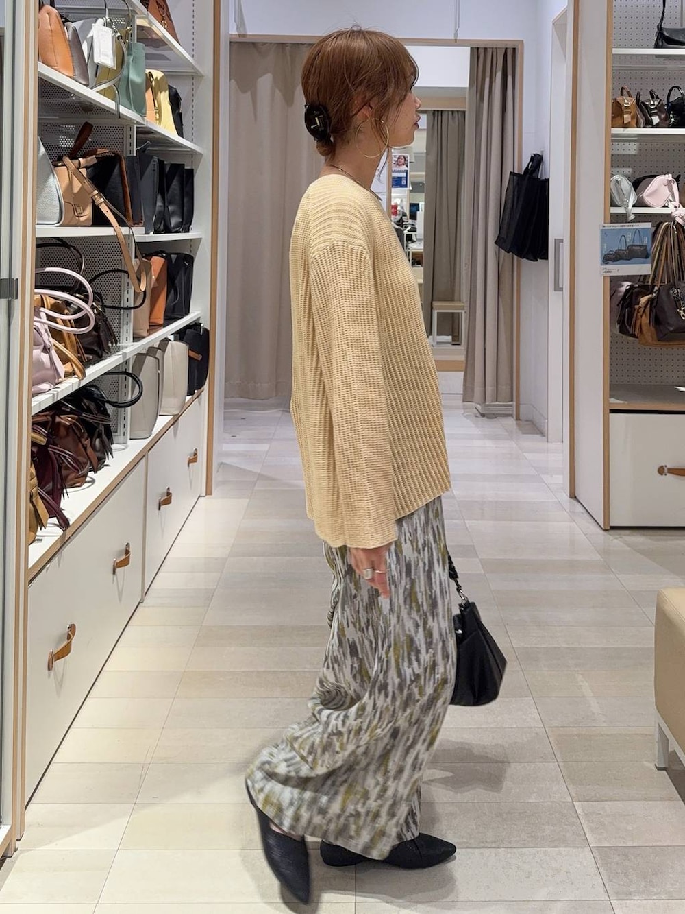 ブラック系のパンプス、ベージュ系のその他パンツ、イエロー系のニット/セーターを着用したレディースの春コーディネートの2枚目の写真