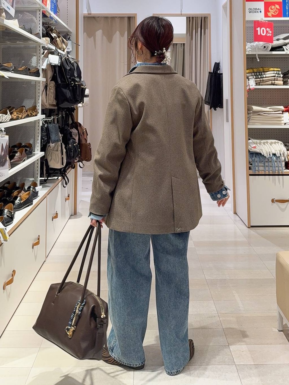 その他のパンプス、ブラウン系のボストンバッグ、ブルー系のデニムパンツを着用したレディースの冬コーディネートの5枚目の写真