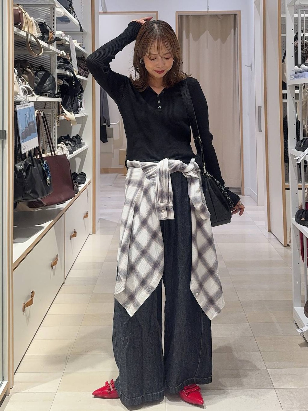 ブラック系のパーカー、ホワイト系のシャツ/ブラウス、ブルー系のデニムパンツを着用したレディースの秋コーディネートの2枚目の写真