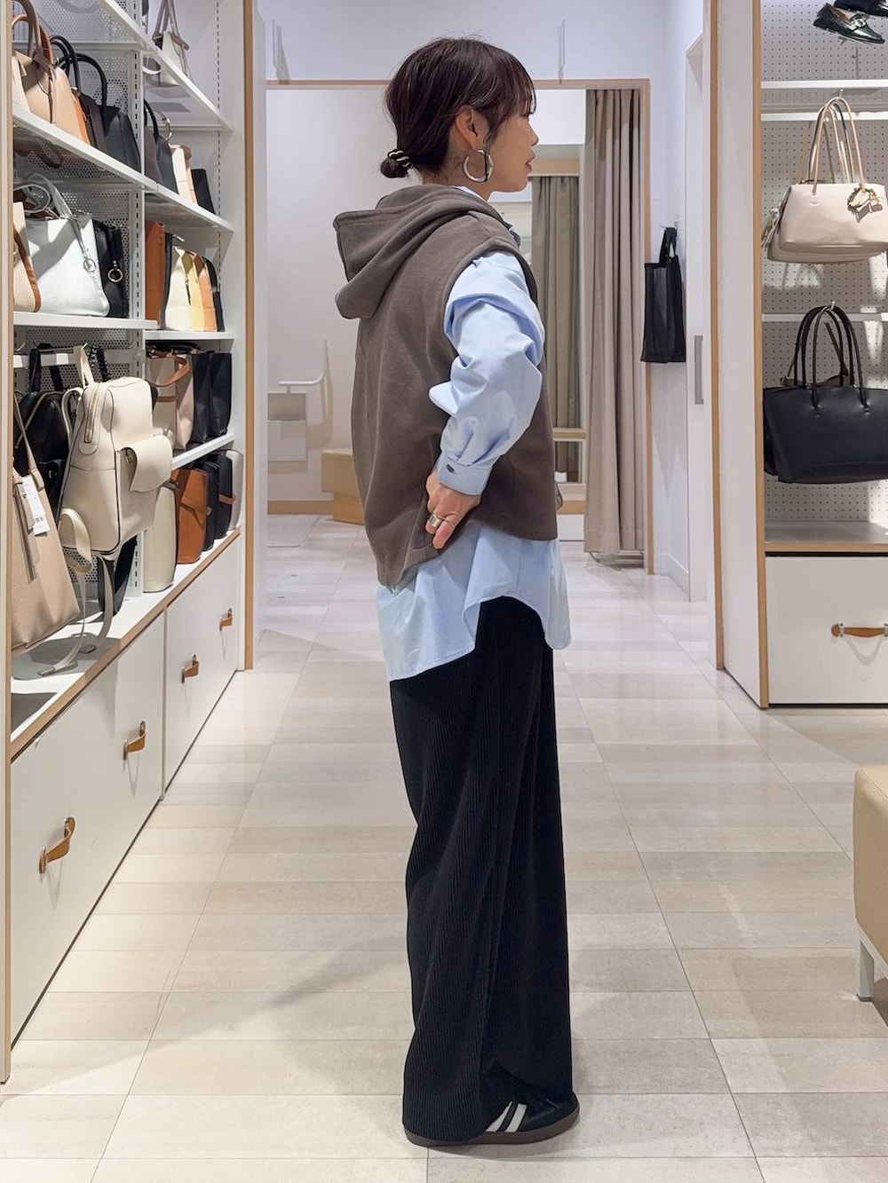 ブルー系のシャツ/ブラウス、ブルー系のデニムジャケット、ブラウン系のベストを着用したレディースの冬コーディネートの6枚目の写真