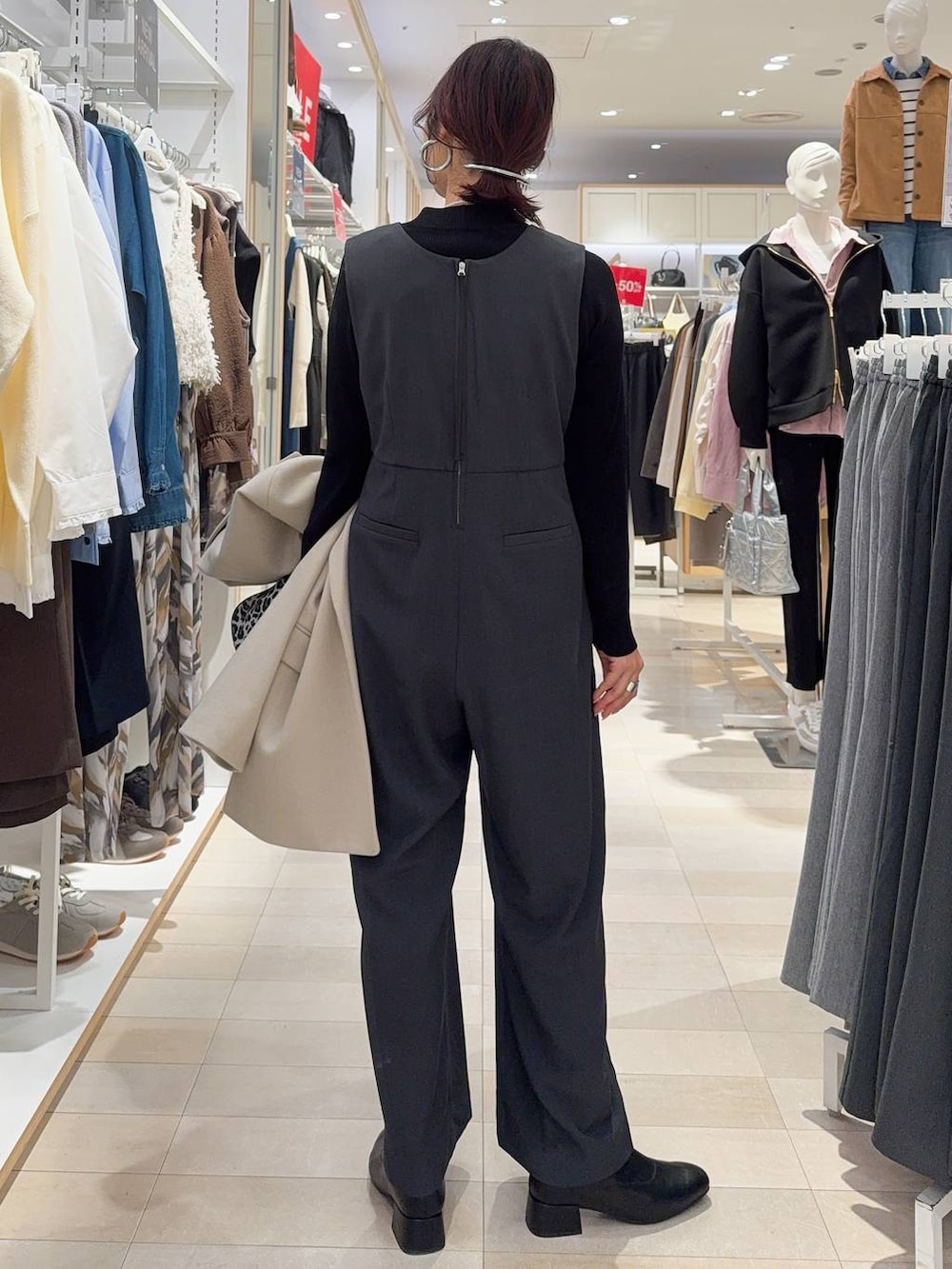 その他のショルダーバッグ、ブラック系のニット/セーター、ブラック系のブーツを着用したレディースの冬コーディネートの6枚目の写真