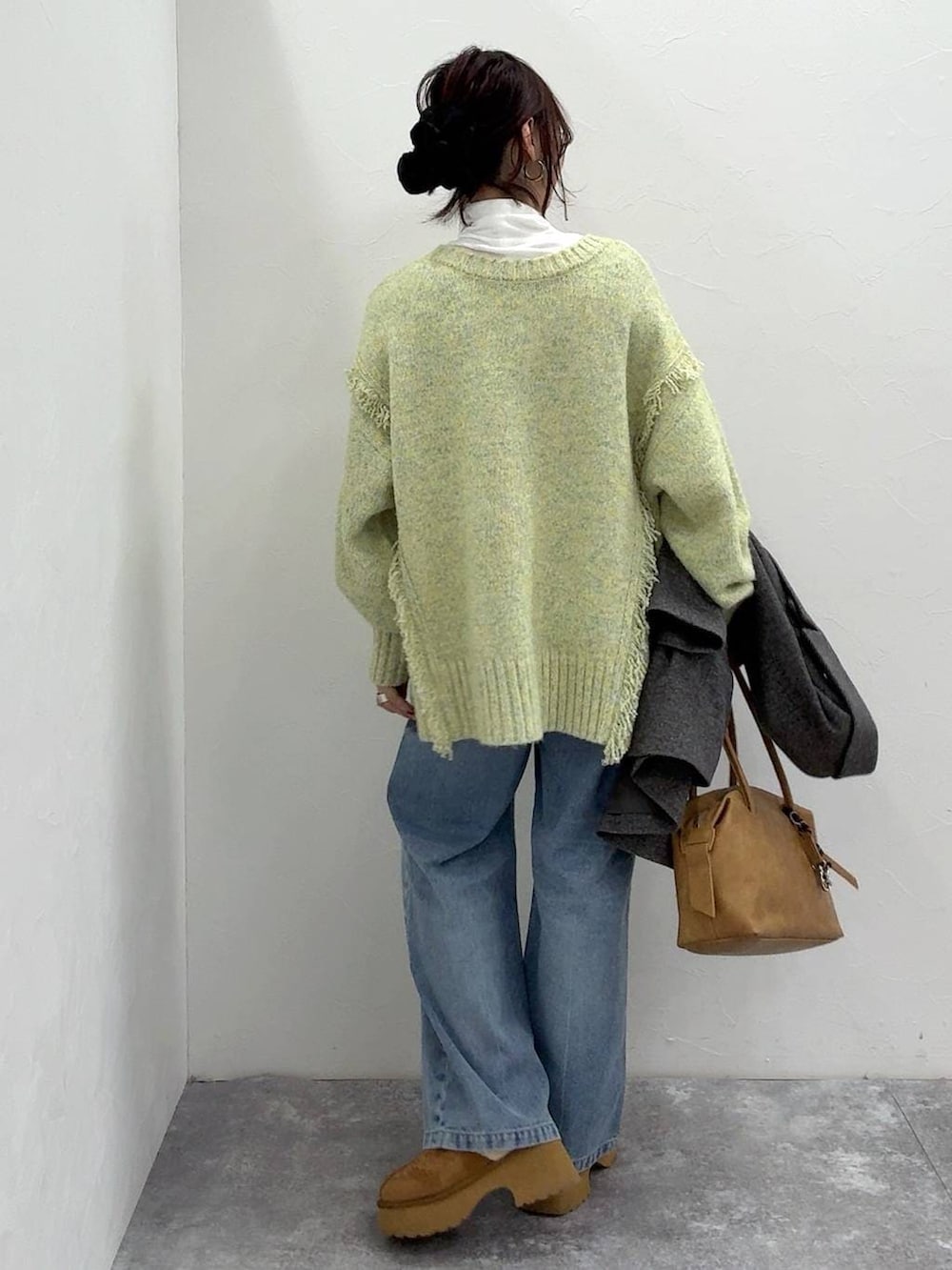 ベージュ系のボストンバッグ、グレー系のチェスターコート、イエロー系のブーツを着用したレディースの冬コーディネートの9枚目の写真