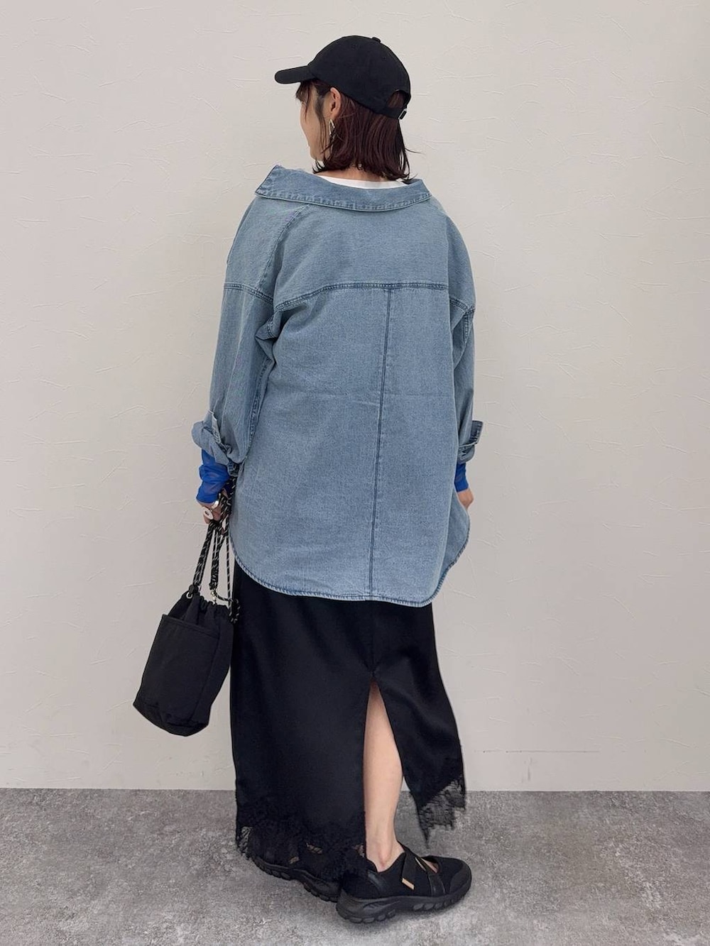 ブラック系のスニーカー、ホワイト系のベスト、シルバー系のネックレスを着用したレディースの春コーディネートの5枚目の写真