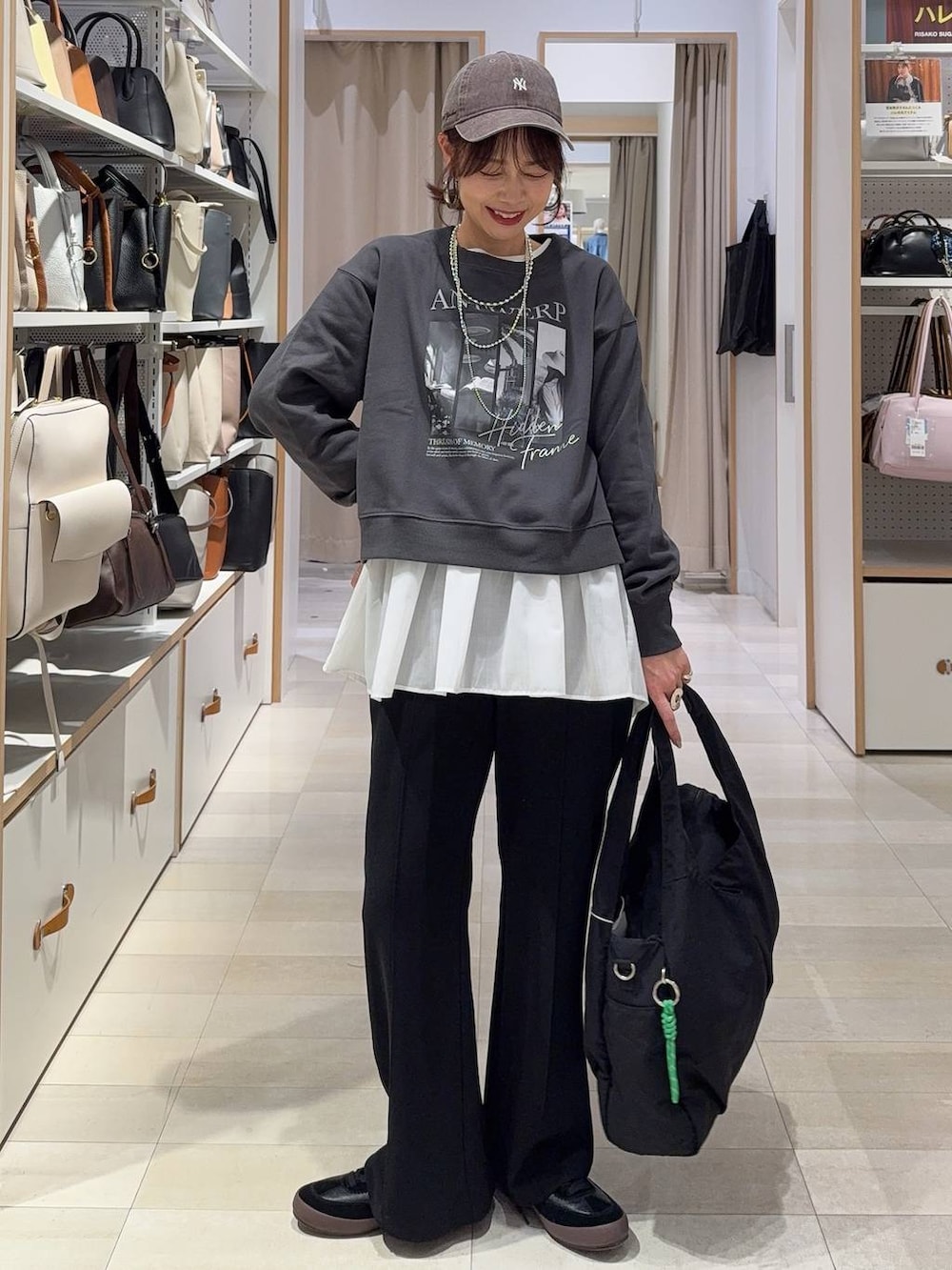 ブラック系のスニーカー、ブラック系のショルダーバッグ、ホワイト系のTシャツ/カットソーを着用したレディースの春コーディネートの3枚目の写真