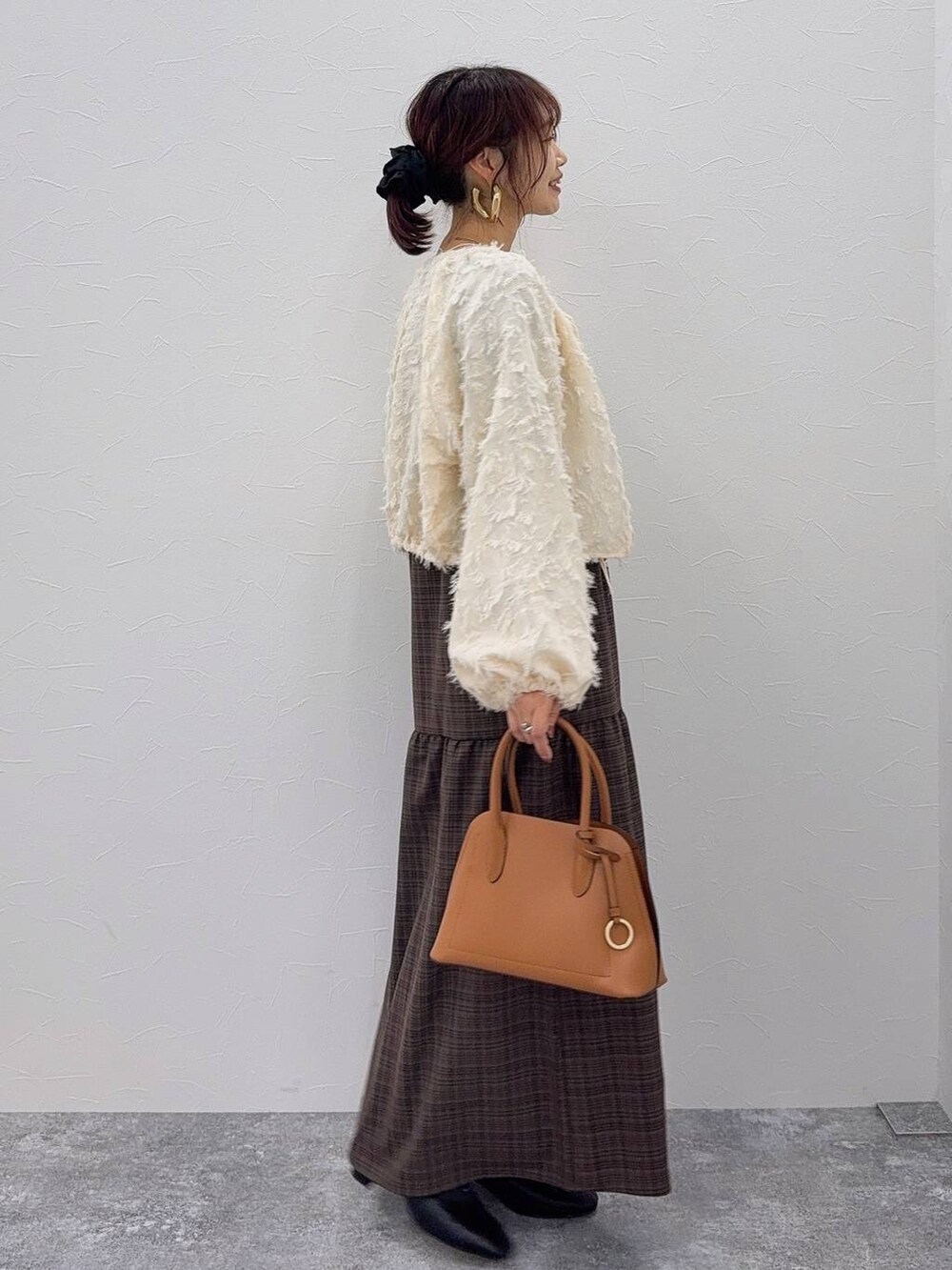 ブラウン系のショルダーバッグ、ブラック系のブーツ、ホワイト系のシャツ/ブラウスを着用したレディースの秋コーディネートの3枚目の写真