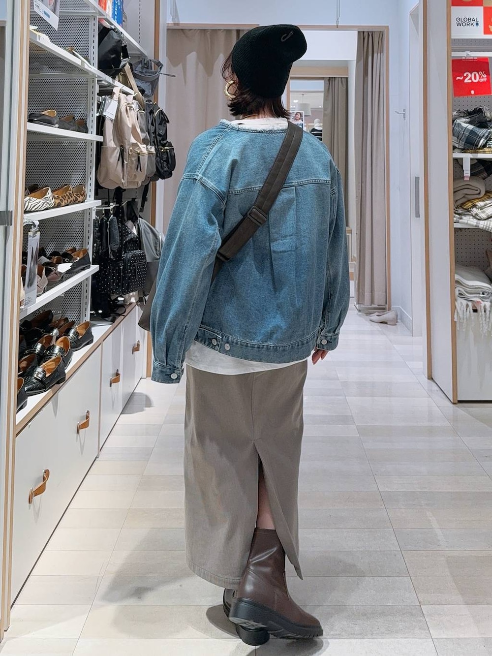 ブラウン系のショルダーバッグ、ブラウン系のスカート、ホワイト系のTシャツ/カットソーを着用したレディースの冬コーディネートの5枚目の写真