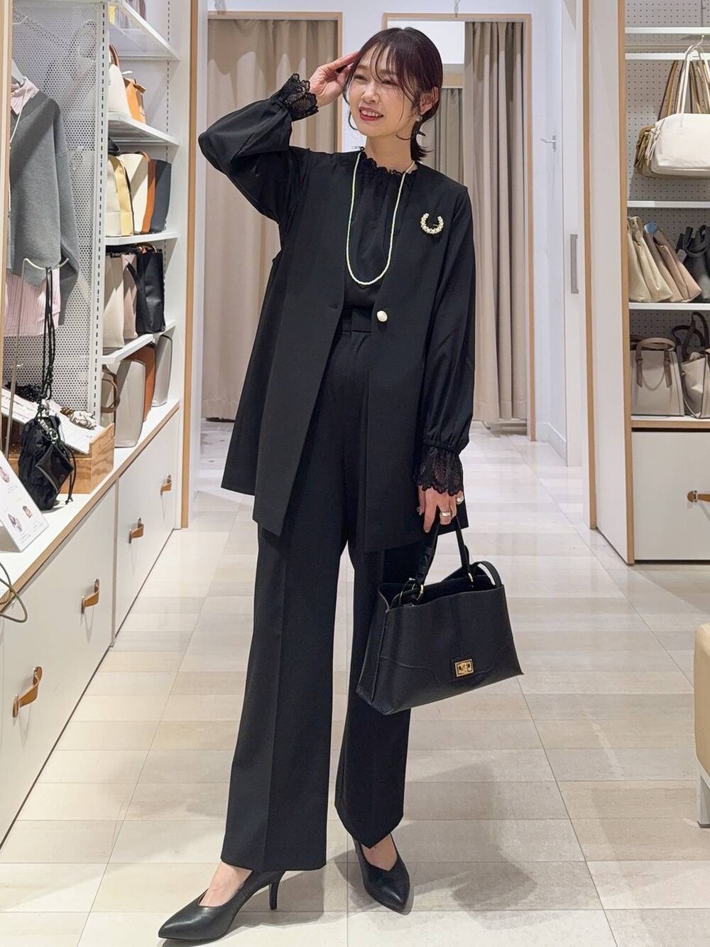 シルバー系のパンプス、ブラック系のその他アウター、ブルー系のデニムパンツを着用したレディースの冬コーディネートの4枚目の写真