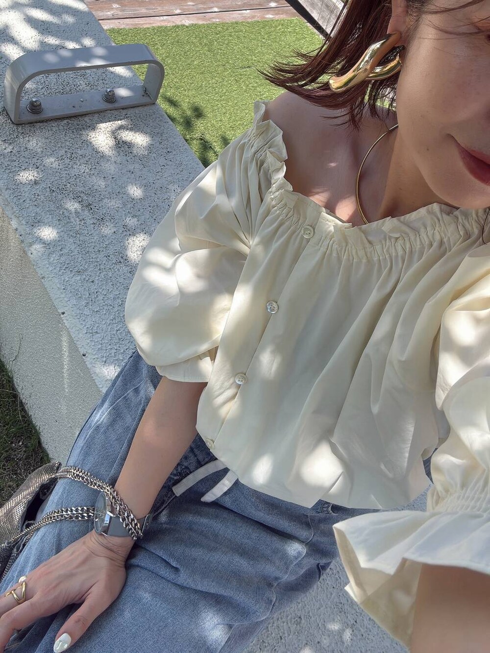 ブルー系のデニムパンツ、ホワイト系のシャツ/ブラウス、ベージュ系のサンダルを着用したレディースの夏コーディネートの2枚目の写真