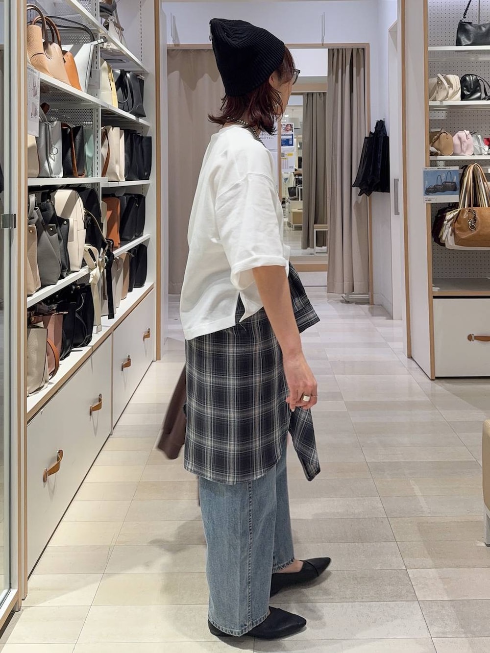 ブラック系のパンプス、ブラック系のハンドバッグ、ブルー系のデニムパンツを着用したレディースの春コーディネートの7枚目の写真