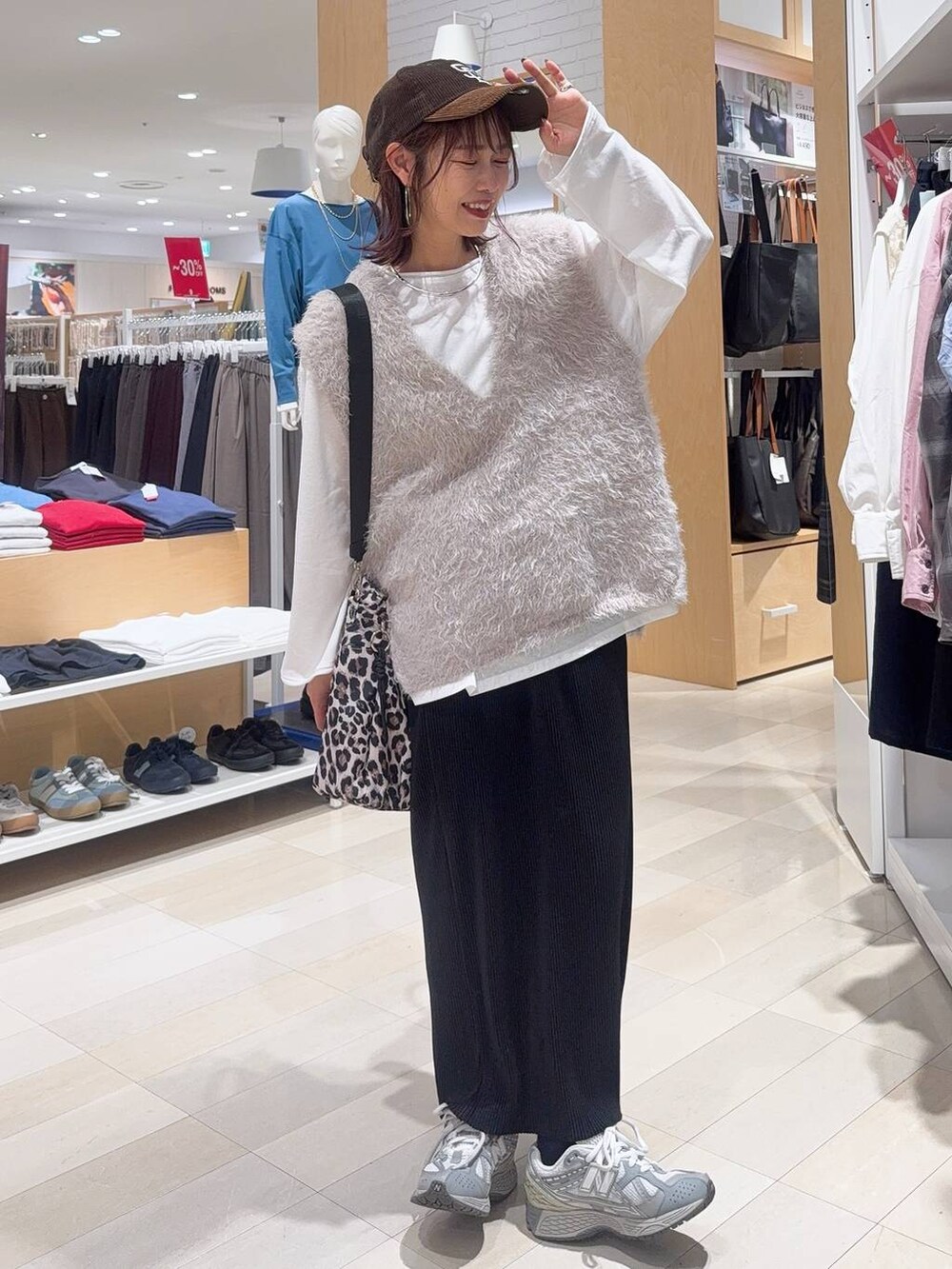 グリーン系のボストンバッグ、ブルー系のシャツ/ブラウス、グレー系のベストを着用したレディースの秋コーディネートの4枚目の写真