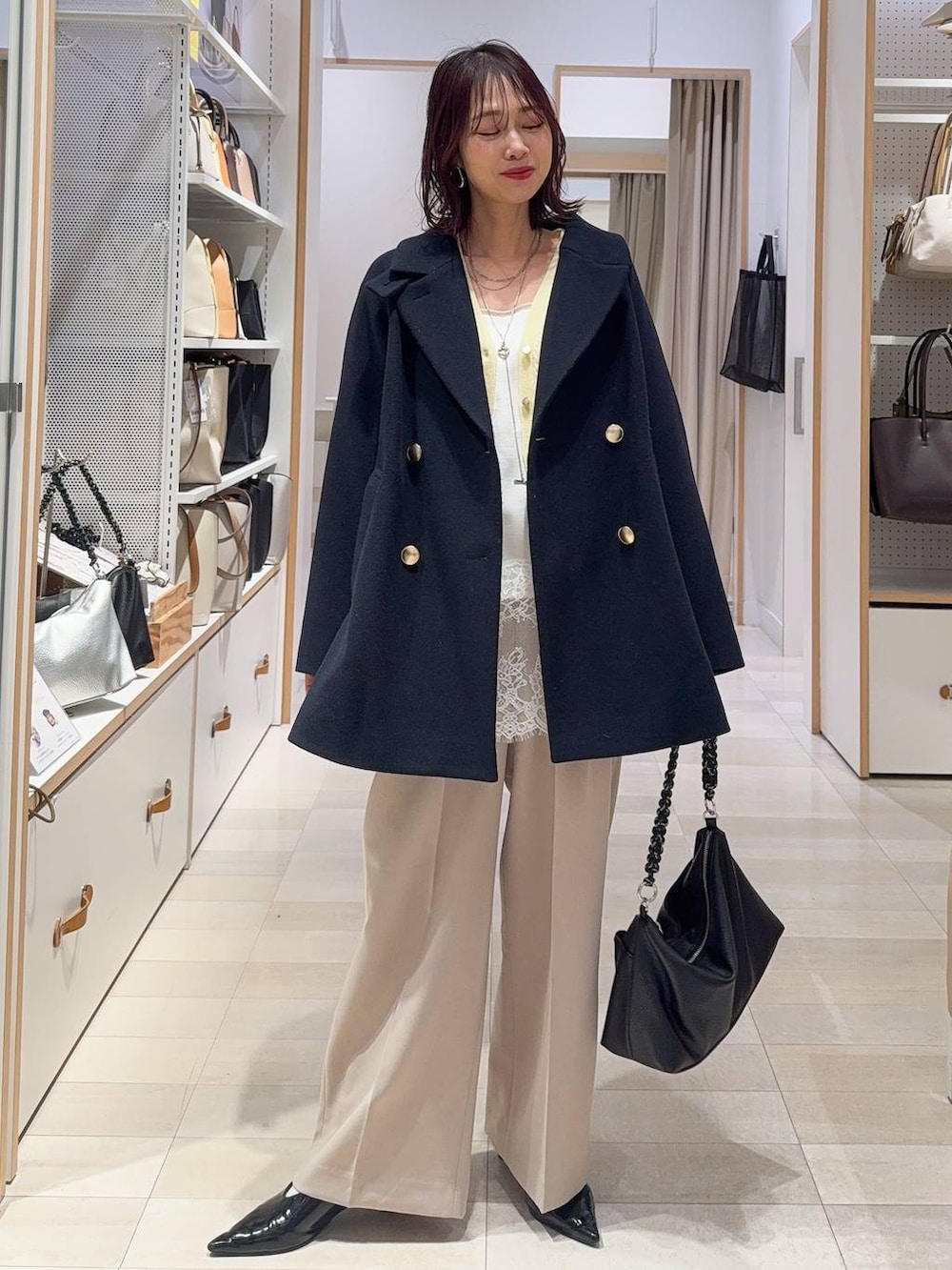 ゴールド系のタンクトップ、ブルー系のチェスターコート、イエロー系のカーディガン/ボレロを着用したレディースの冬コーディネートの2枚目の写真