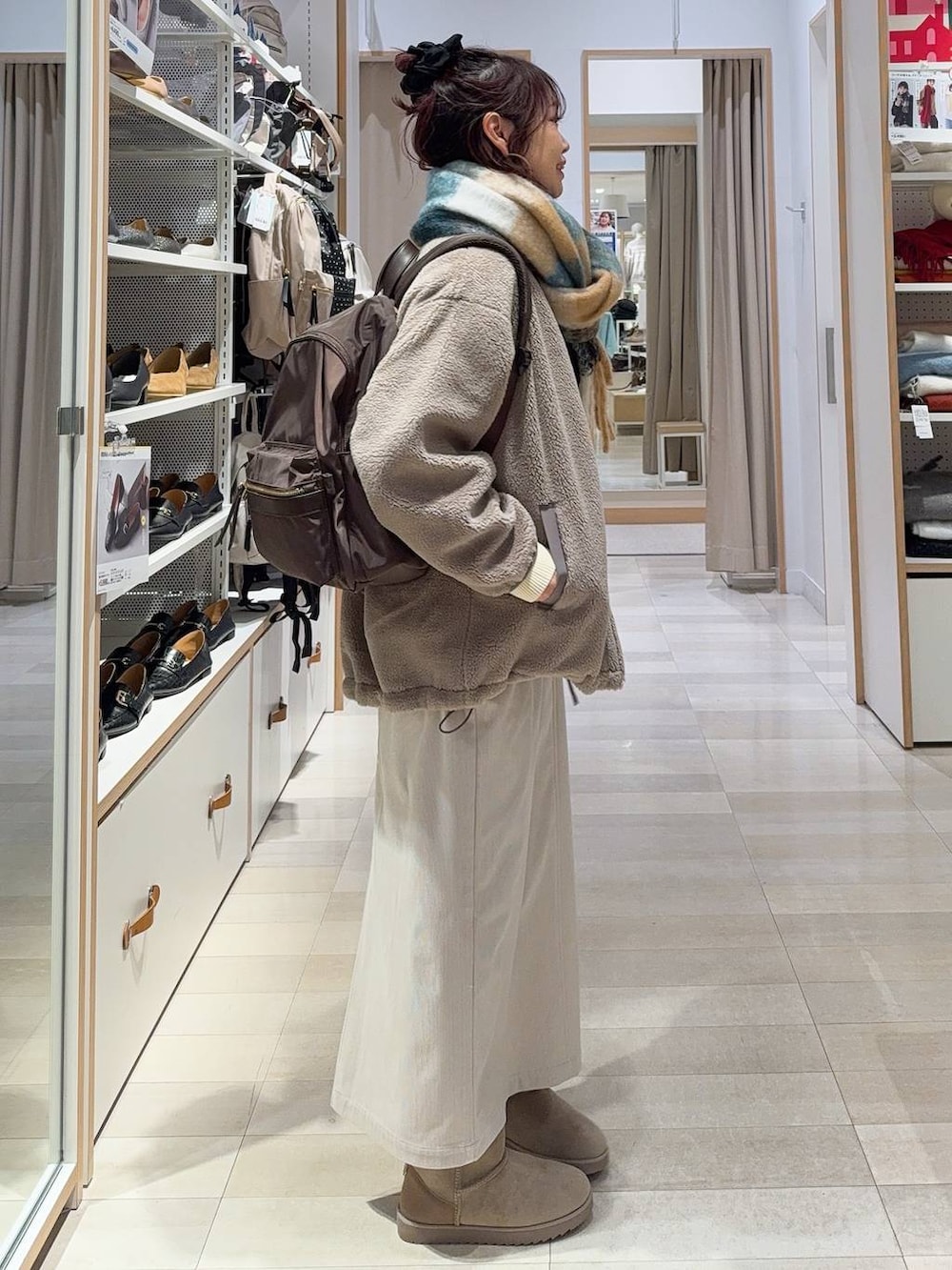 ブラウン系のブルゾン、グレー系のスカート、イエロー系のニット/セーターを着用したレディースの冬コーディネートの5枚目の写真