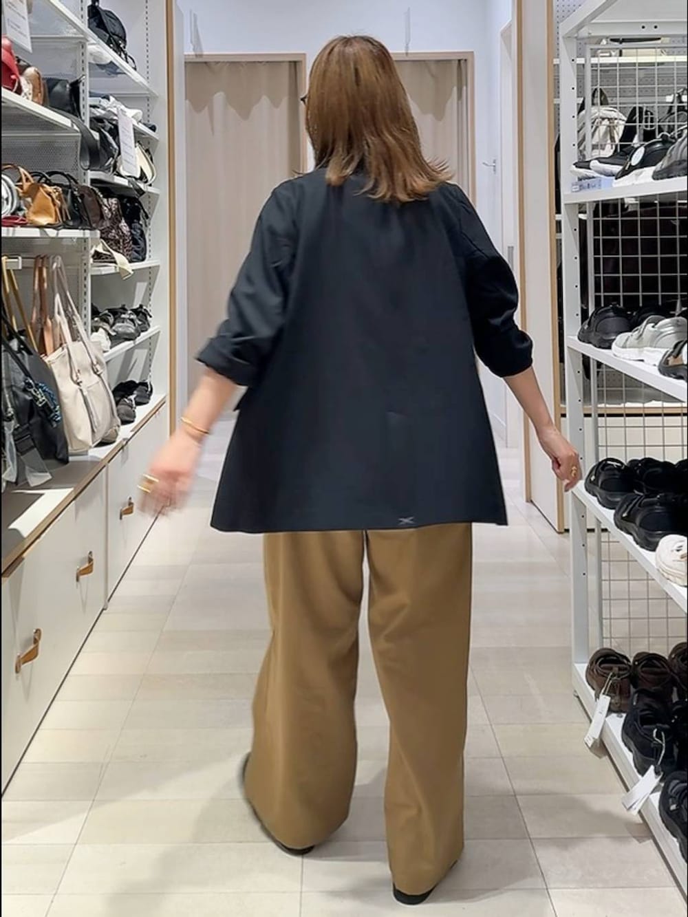 ブラック系のローファー、ブラウン系のボストンバッグ、ホワイト系のTシャツ/カットソーを着用したレディースの夏コーディネートの3枚目の写真