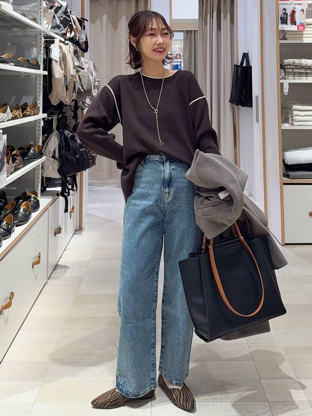 ブラック系のダウンジャケット/コート、ブラウン系のワンピース、ブラック系のブーツを着用したレディースの冬コーディネートの4枚目の写真