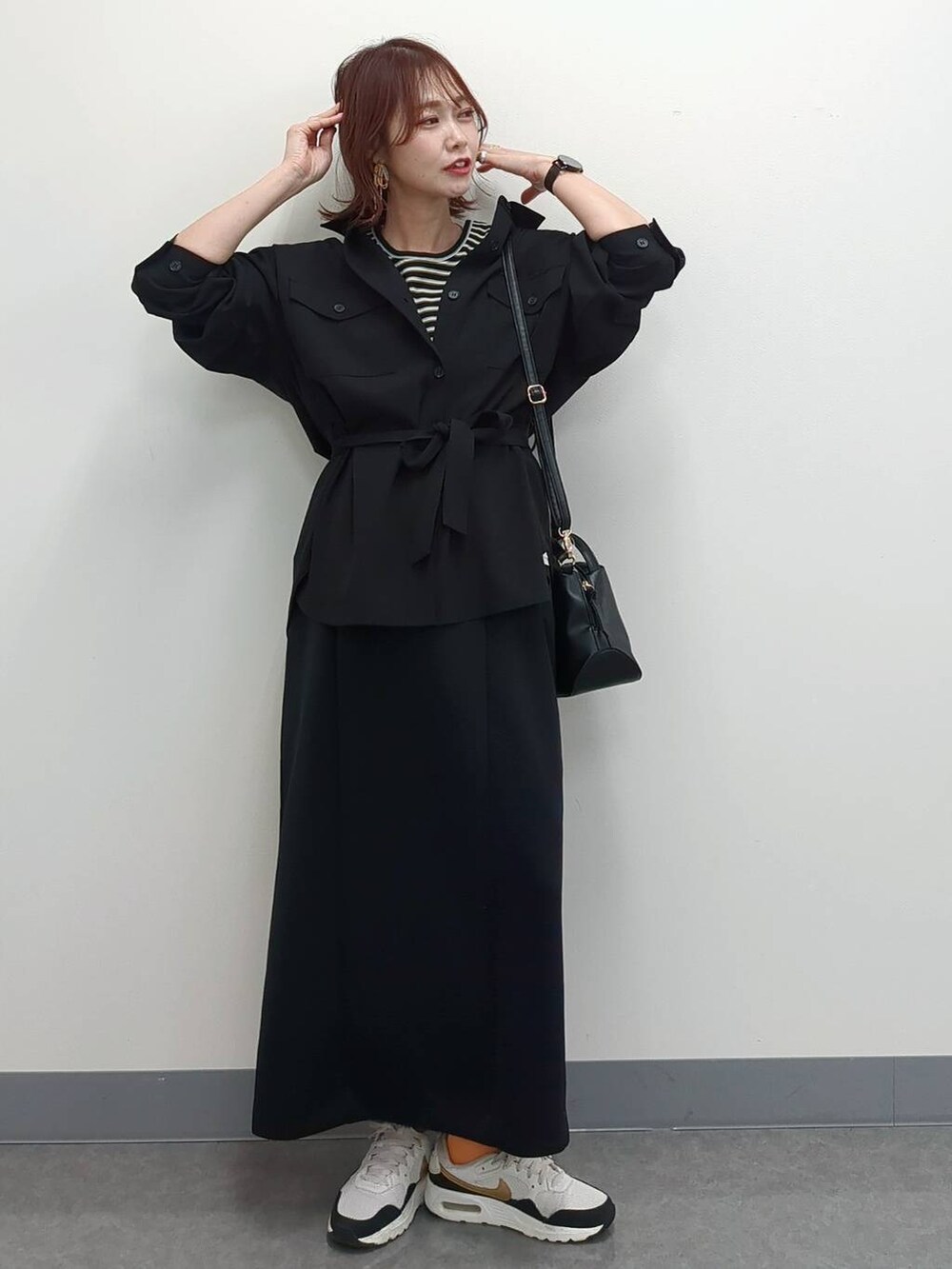 ホワイト系のショルダーバッグ、ブラック系のシャツ/ブラウス、ベージュ系のキャミソールを着用したレディースの春コーディネートの2枚目の写真