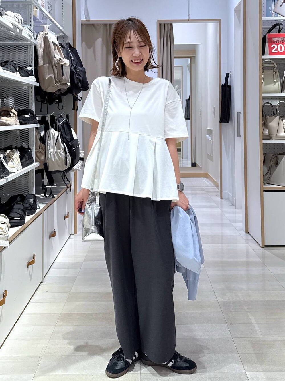 シルバー系のショルダーバッグ、ブルー系のカーディガン/ボレロ、ホワイト系のTシャツ/カットソーを着用したレディースの春コーディネートの2枚目の写真