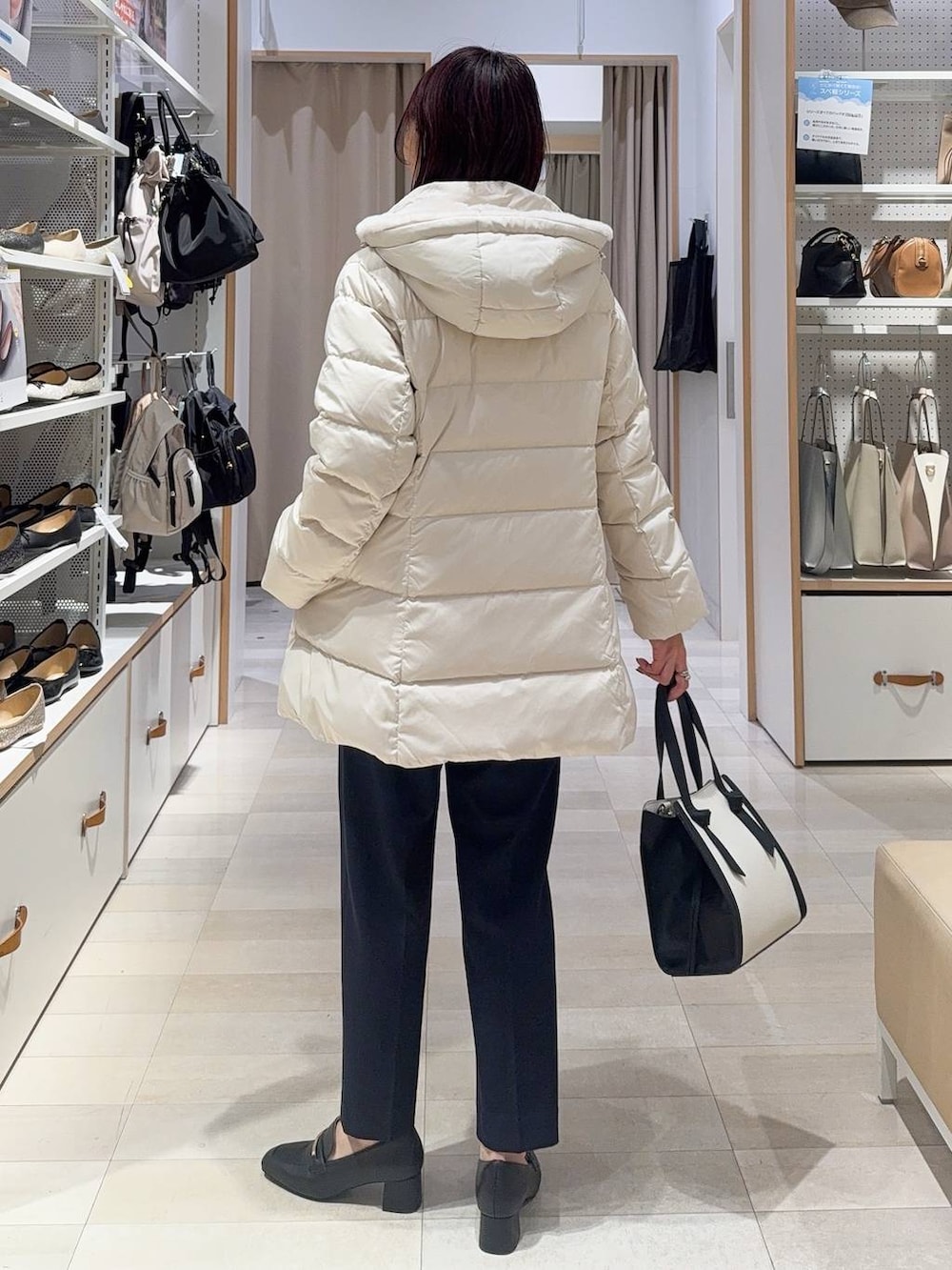 ブラック系のローファー、ホワイト系のショルダーバッグ、ベージュ系のダウンジャケット/コートを着用したレディースの秋コーディネートの5枚目の写真