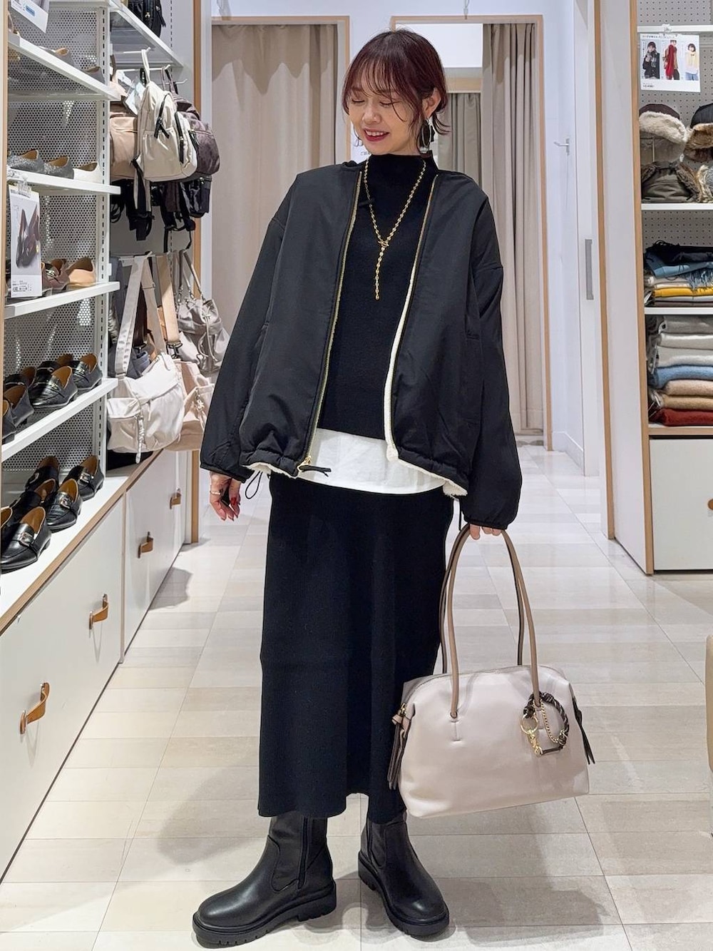 ホワイト系のブルゾン、グレー系のスカート、ホワイト系のTシャツ/カットソーを着用したレディースの冬コーディネートの3枚目の写真