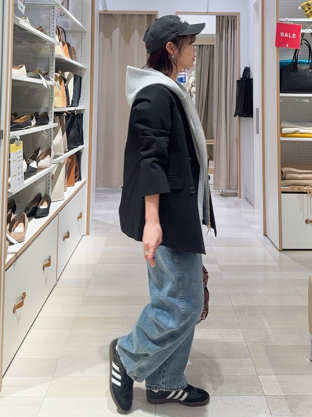 ブラック系のキャミソール、ブラック系のテーラードジャケット、ブルー系のデニムパンツを着用したレディースの冬コーディネートの5枚目の写真