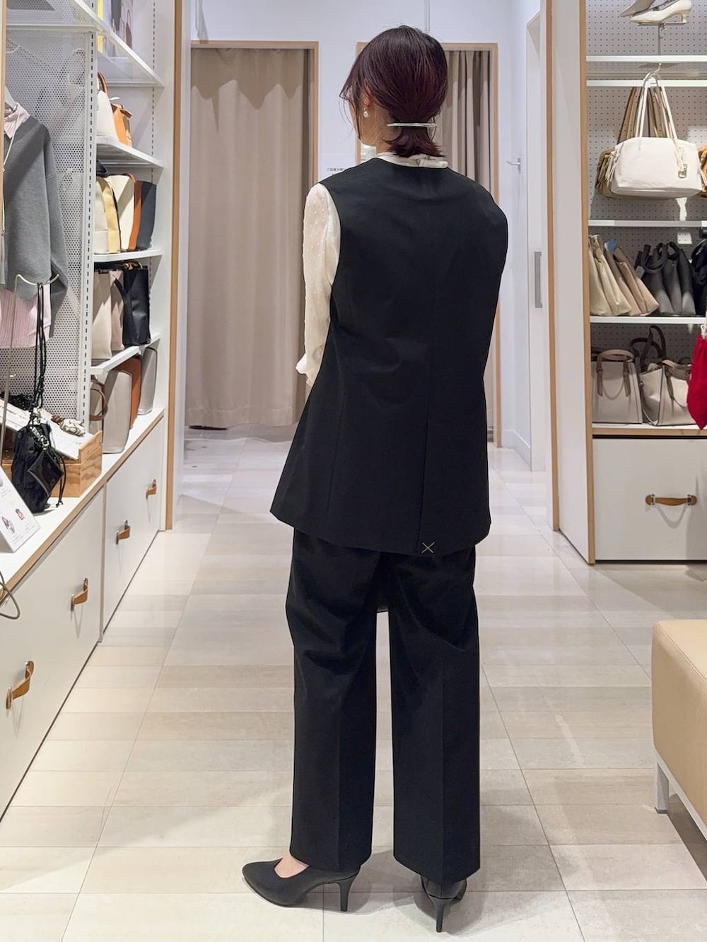 ブラック系のスラックス、ホワイト系のシャツ/ブラウス、ブラック系のその他アウターを着用したレディースの冬コーディネートの6枚目の写真