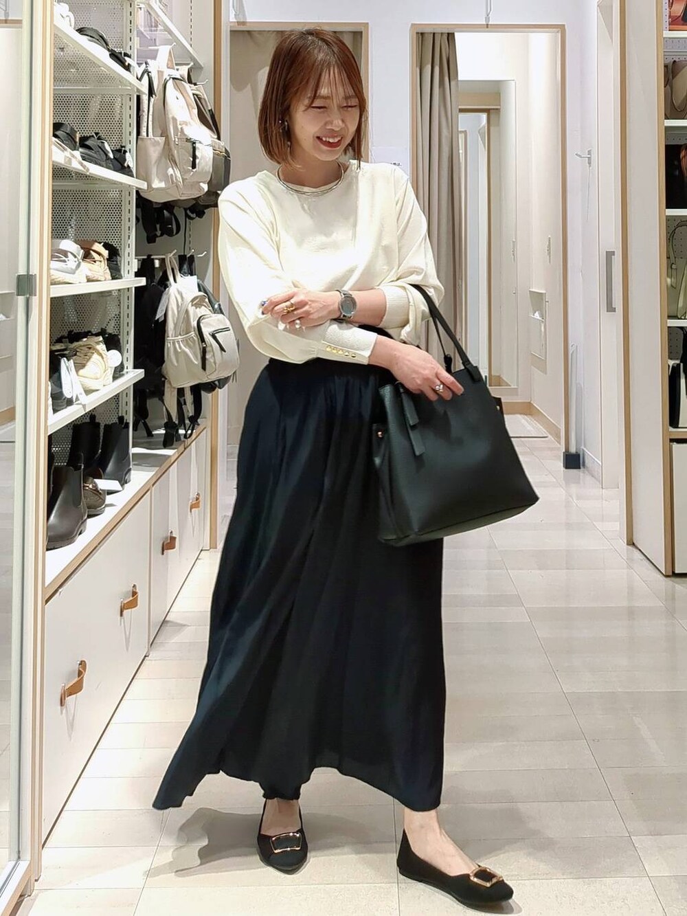 ブルー系のその他パンツ、ベージュ系のベスト、ブラック系のショルダーバッグを着用したレディースの春コーディネートの4枚目の写真