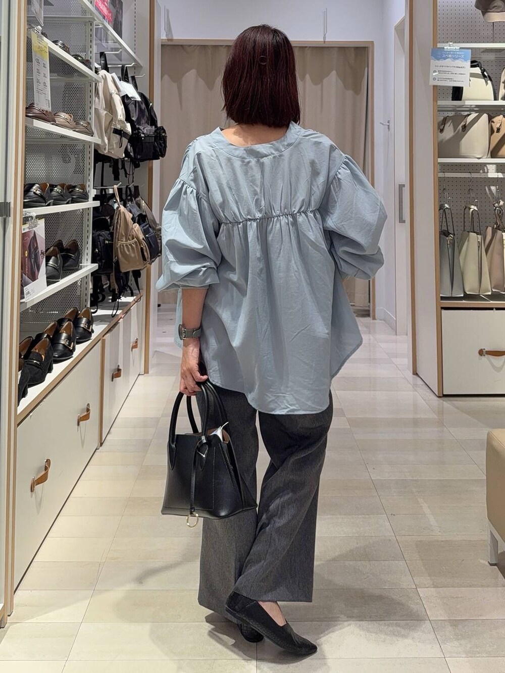 ブラック系のパンプス、グレー系のその他パンツ、ブルー系のシャツ/ブラウスを着用したレディースの秋コーディネートの5枚目の写真