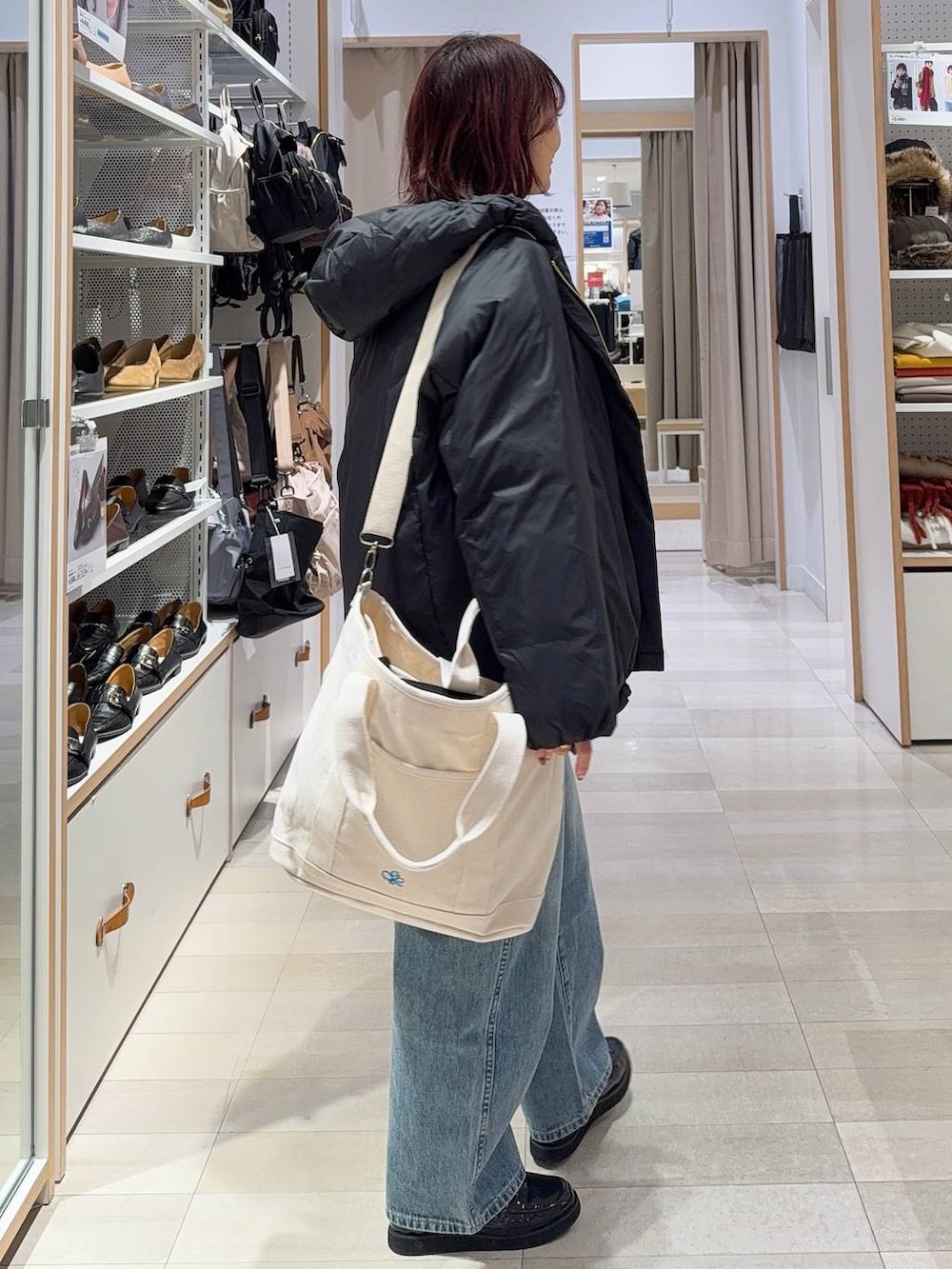 ブラック系のローファー、ブラック系のショルダーバッグ、ブラック系のダウンジャケット/コートを着用したレディースの冬コーディネートの6枚目の写真