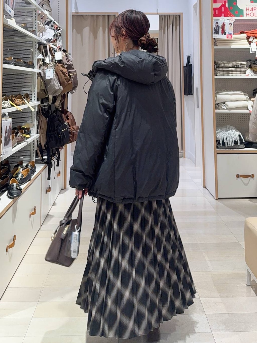 ブラウン系のショルダーバッグ、ブラック系のダウンジャケット/コート、ベージュ系のカーディガン/ボレロを着用したレディースの冬コーディネートの7枚目の写真