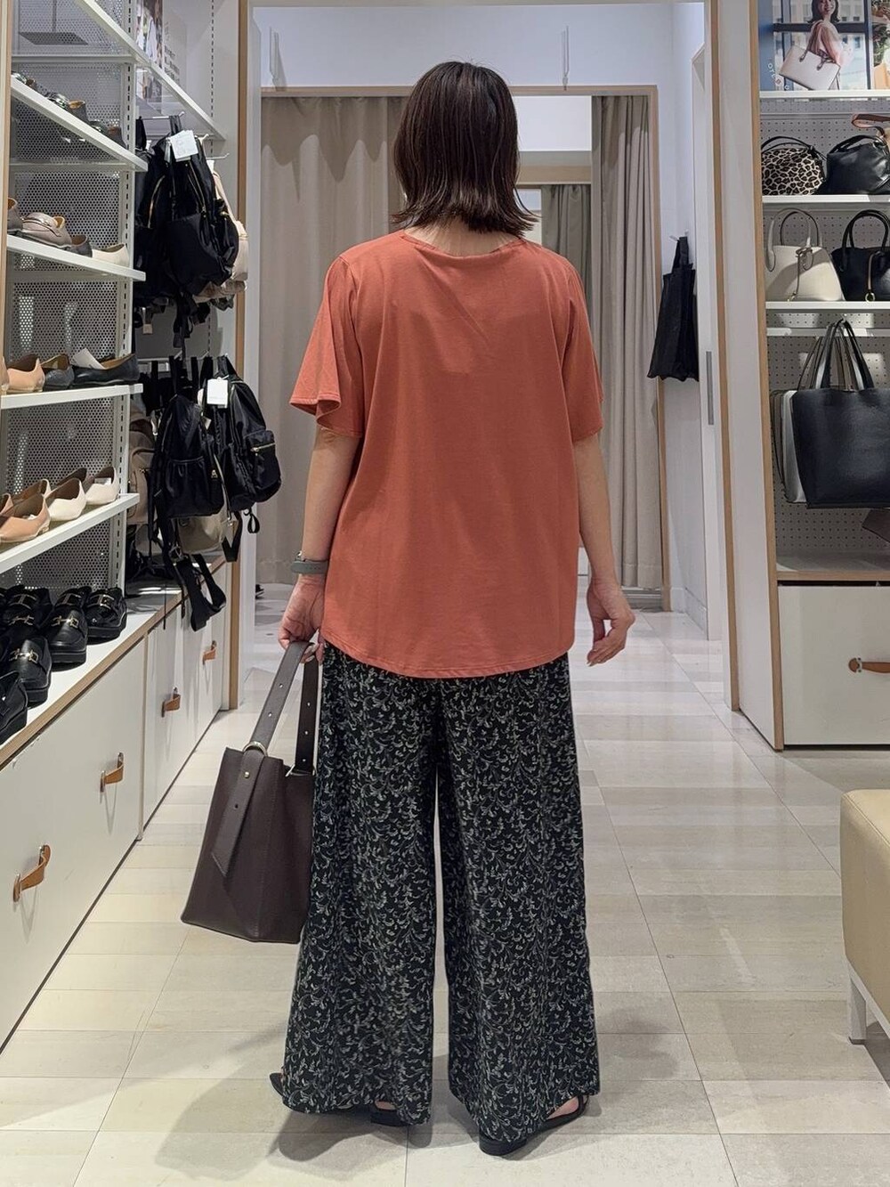 ブラウン系のTシャツ/カットソー、ホワイト系のショルダーバッグ、ブラック系のサンダルを着用したレディースの夏コーディネートの6枚目の写真