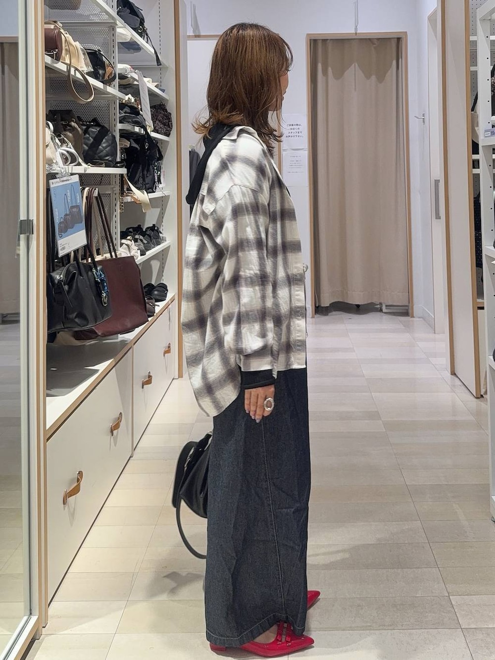 ブラック系のパーカー、ホワイト系のシャツ/ブラウス、ブルー系のデニムパンツを着用したレディースの秋コーディネートの8枚目の写真