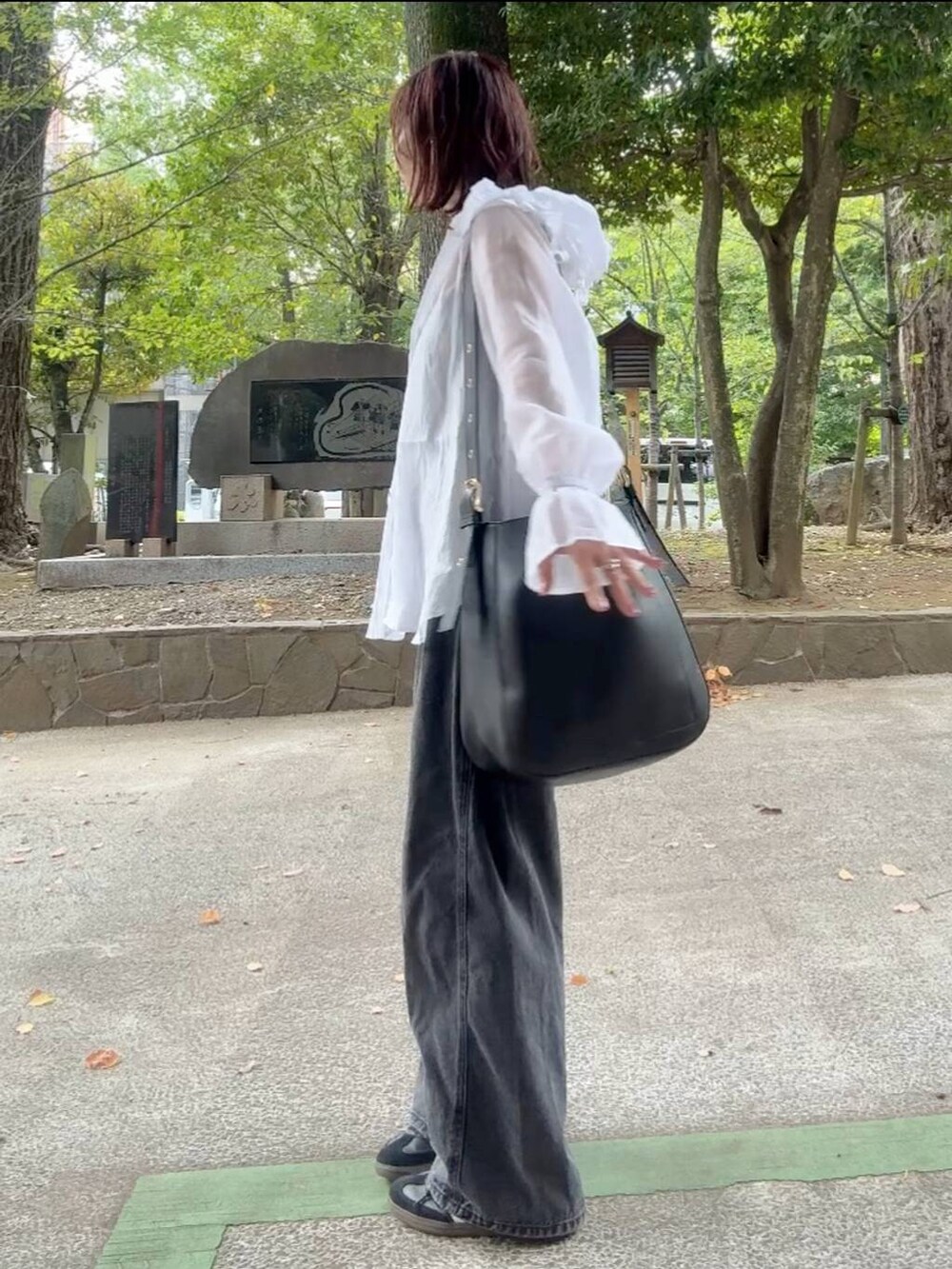 ブラック系のショルダーバッグ、ブラック系のキャミソール、ホワイト系のシャツ/ブラウスを着用したレディースの秋コーディネートの5枚目の写真