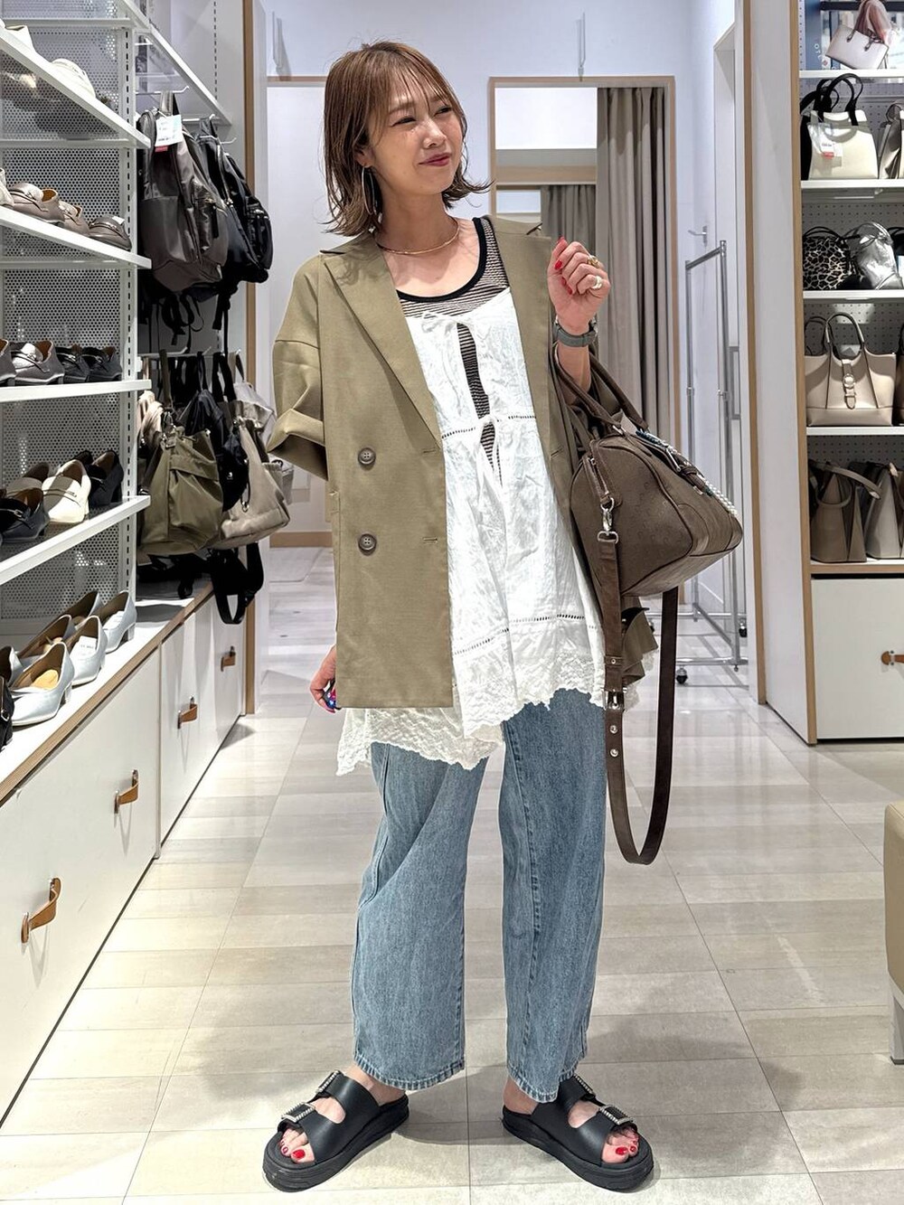 ブルー系のデニムパンツ、ベージュ系のキャミソール、ブラウン系のTシャツ/カットソーを着用したレディースの夏コーディネートの4枚目の写真