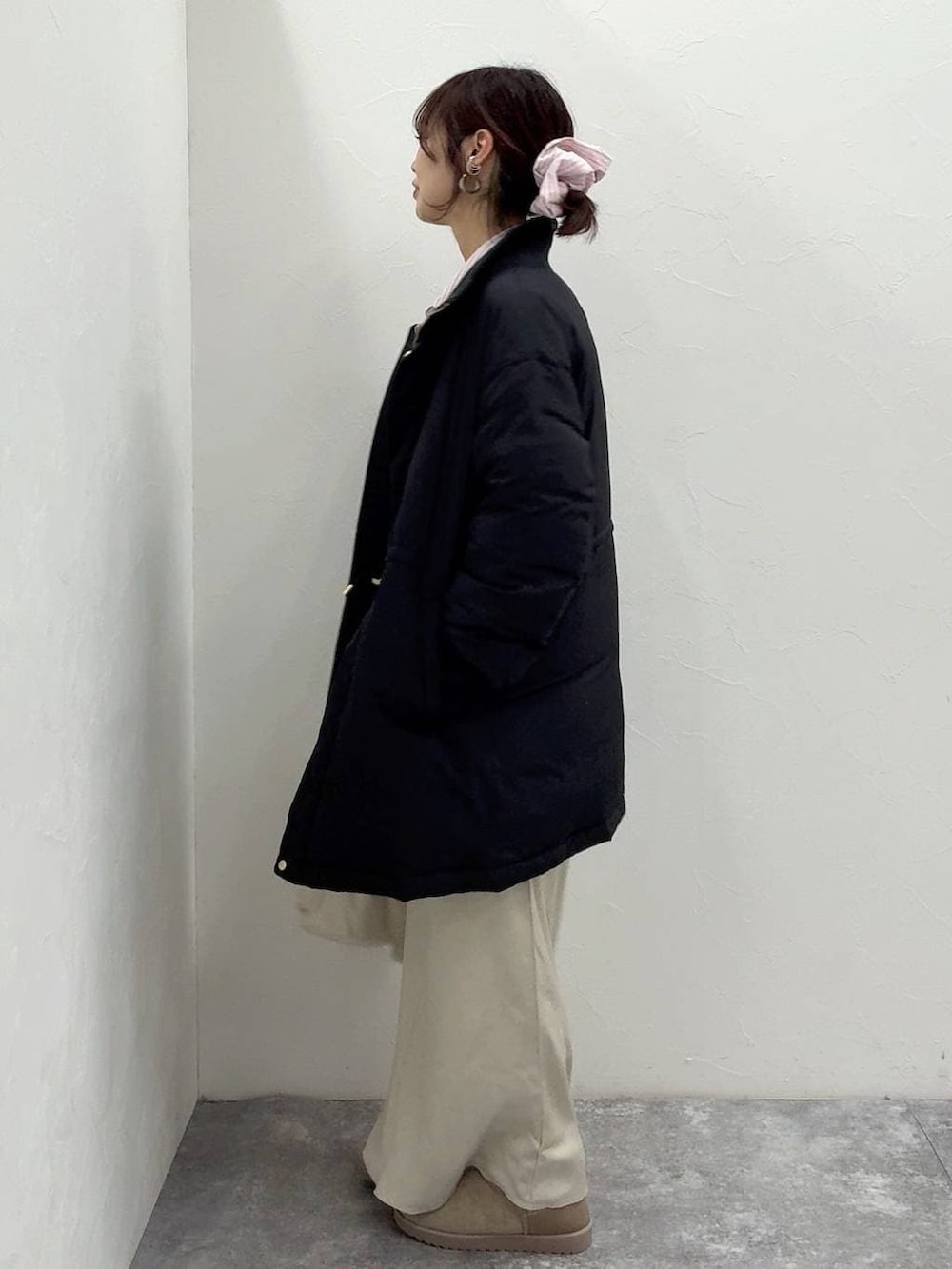 ホワイト系のショルダーバッグ、ブラック系のダウンジャケット/コート、ホワイト系のスカートを着用したレディースの冬コーディネートの4枚目の写真