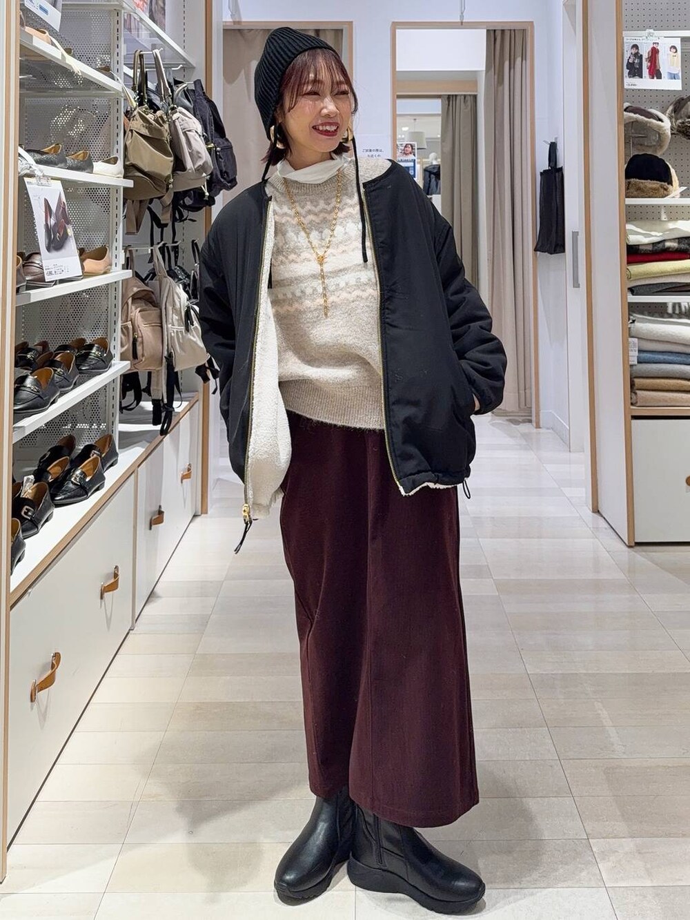 ホワイト系のブルゾン、レッド系のスカート、ベージュ系のトートバッグを着用したレディースの秋コーディネートの2枚目の写真