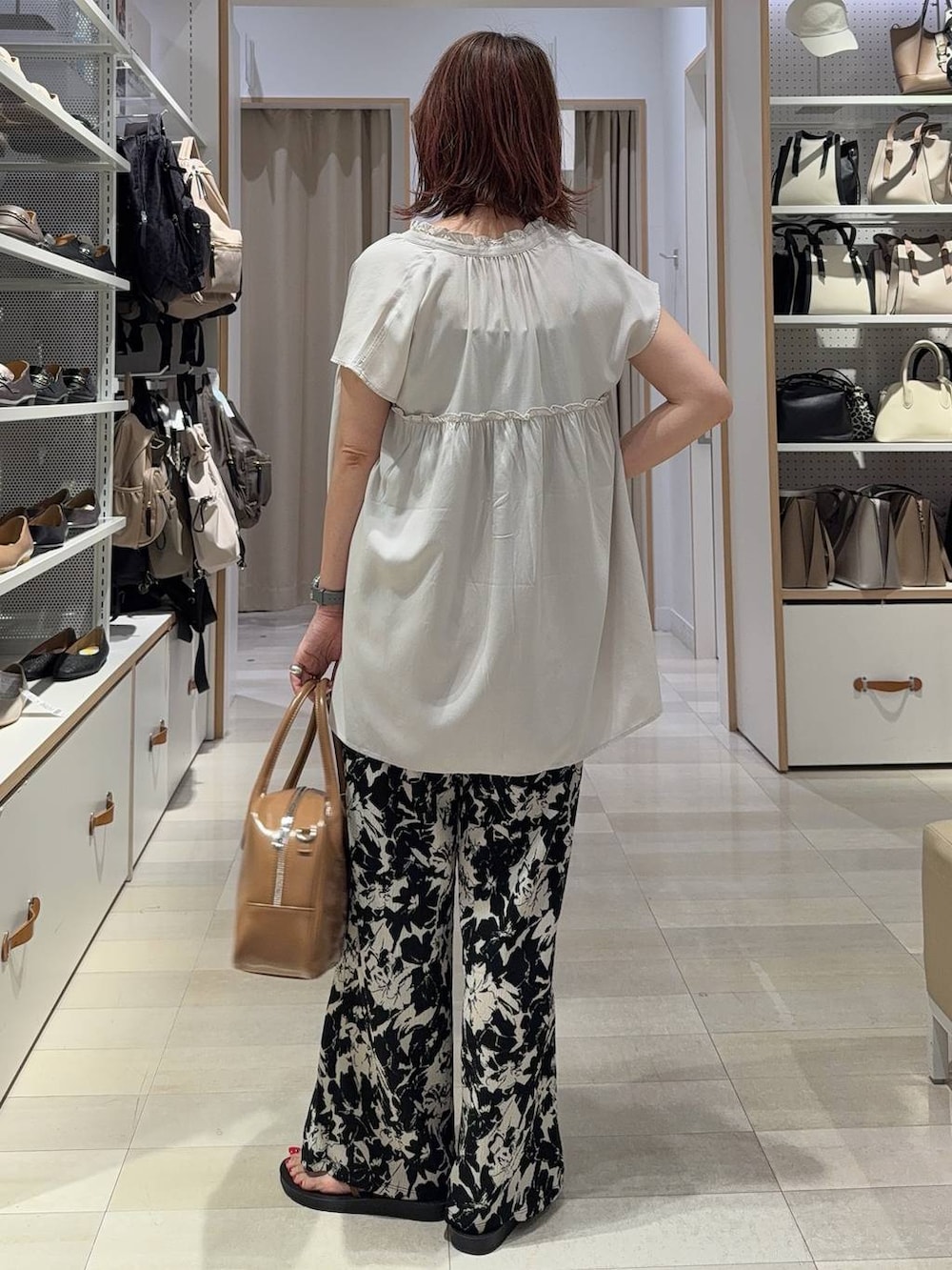 ブルー系のデニムパンツ、ブラック系のショルダーバッグ、ブラック系のサンダルを着用したレディースの夏コーディネートの6枚目の写真