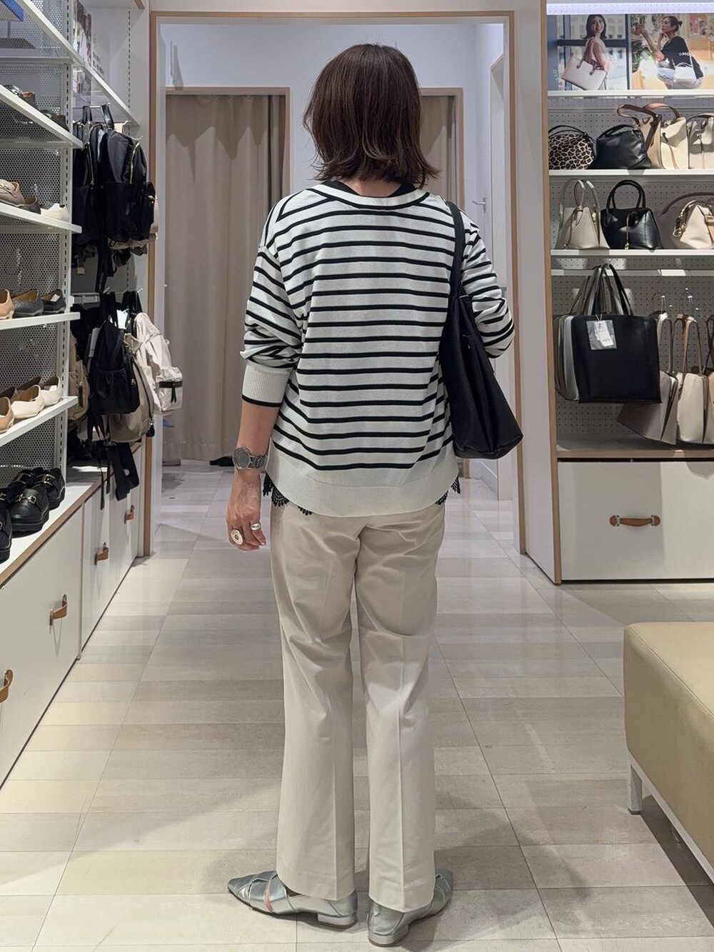 ブラック系のショルダーバッグ、ブルー系のカーディガン/ボレロ、グレー系のパンプスを着用したレディースの夏コーディネートの6枚目の写真