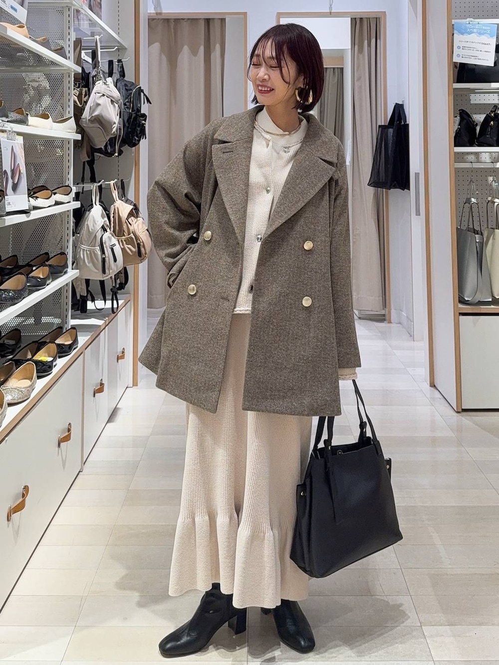 ベージュ系のボストンバッグ、グレー系のチェスターコート、イエロー系のブーツを着用したレディースの冬コーディネートの5枚目の写真