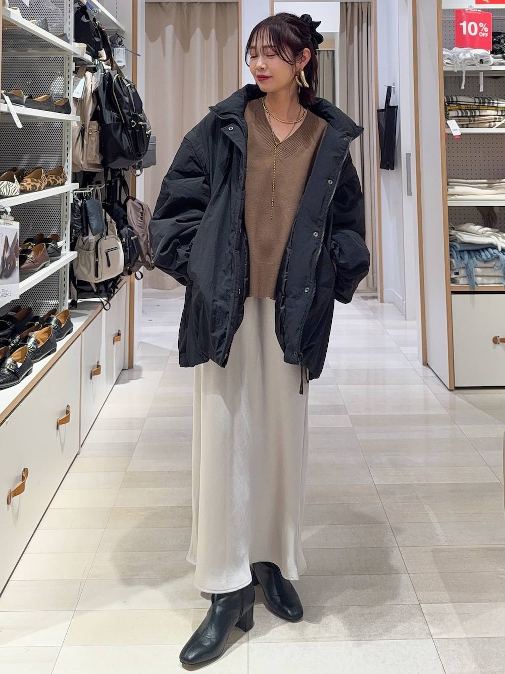 ベージュ系のショルダーバッグ、ベージュ系のパンプス、ホワイト系のキャミソールを着用したレディースの冬コーディネートの3枚目の写真