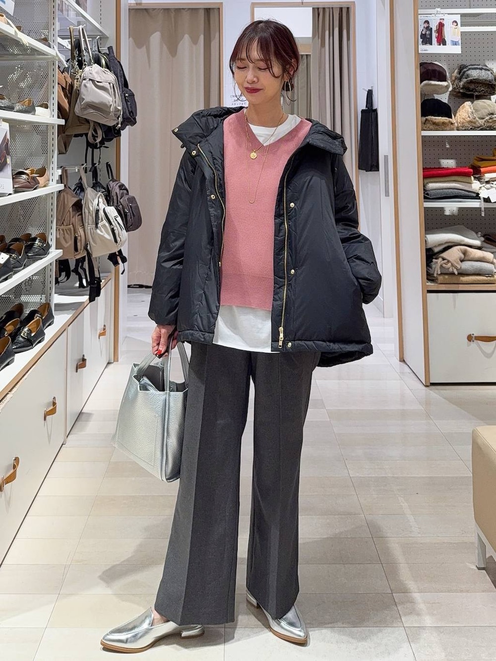 ブラウン系のショルダーバッグ、ブラック系のダウンジャケット/コート、ベージュ系のカーディガン/ボレロを着用したレディースの冬コーディネートの5枚目の写真