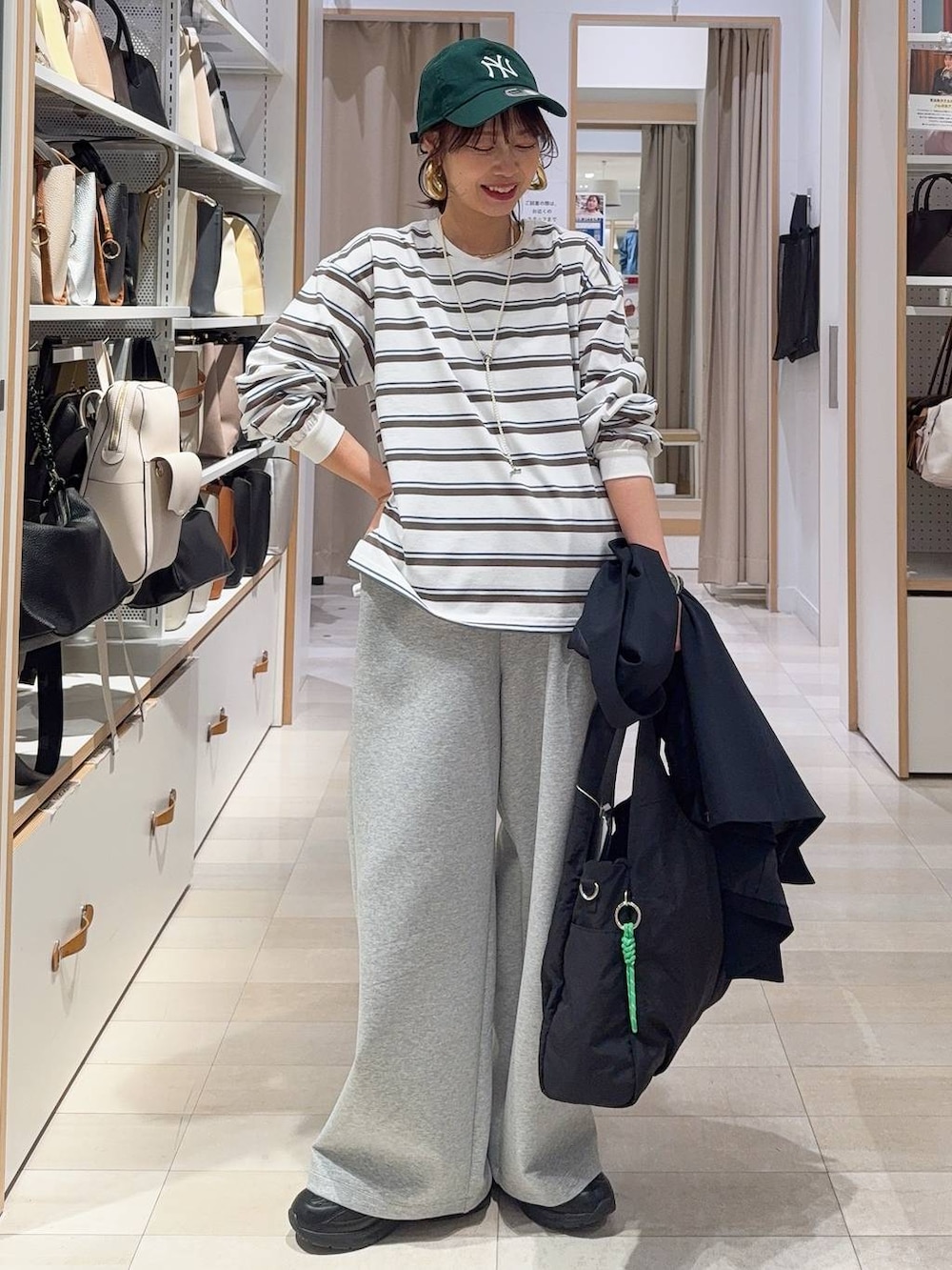 ブラック系のスニーカー、ブラック系のトートバッグ、ブルー系のテーラードジャケットを着用したレディースの冬コーディネートの2枚目の写真