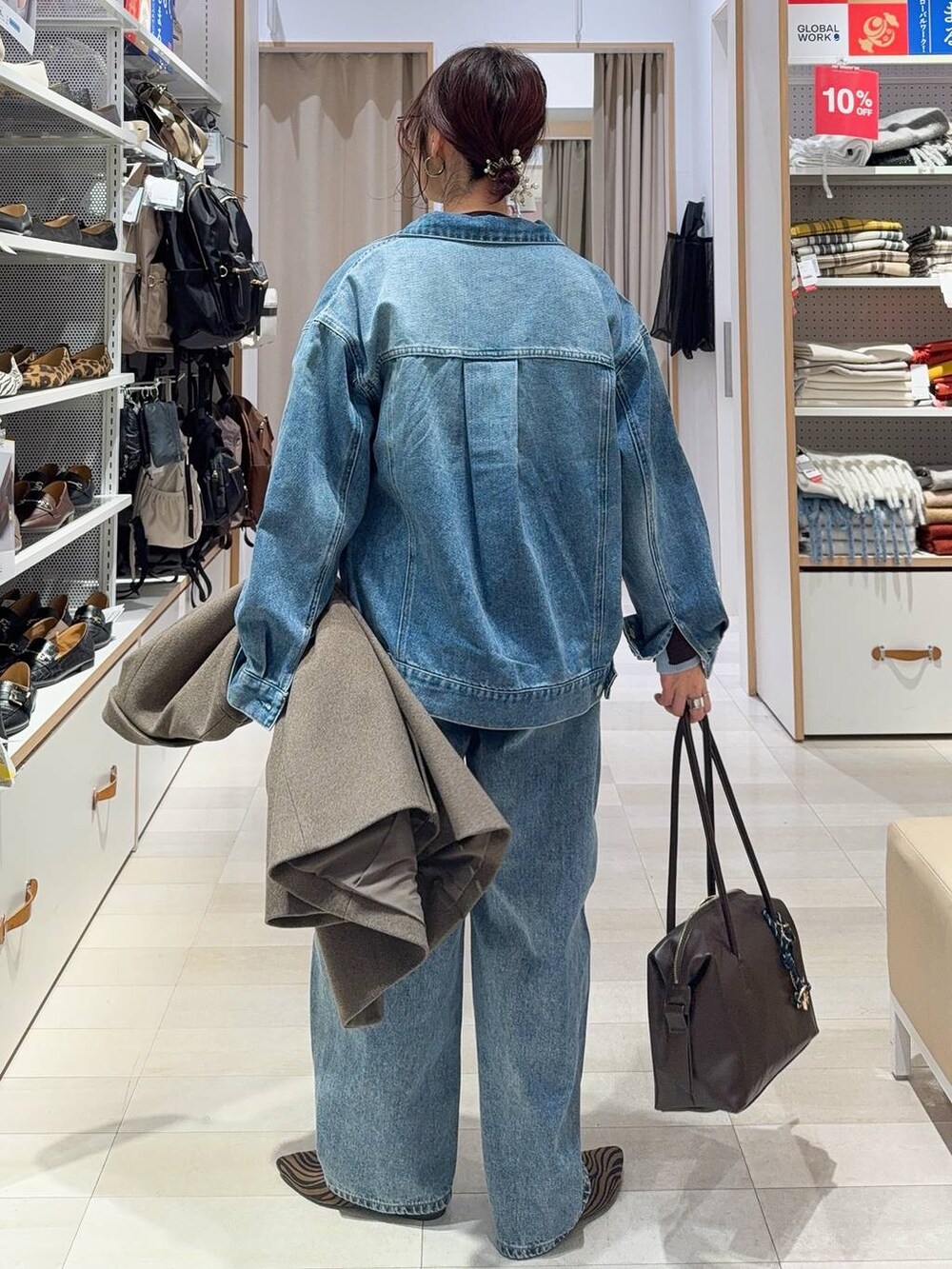 その他のパンプス、ブラウン系のボストンバッグ、ブルー系のデニムパンツを着用したレディースの冬コーディネートの7枚目の写真