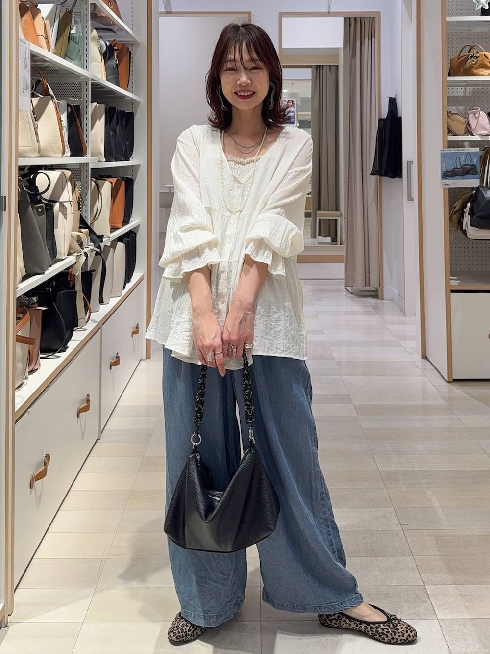 ブラウン系のベスト、ブルー系のデニムパンツ、その他のネックレスを着用したレディースの春コーディネートの2枚目の写真