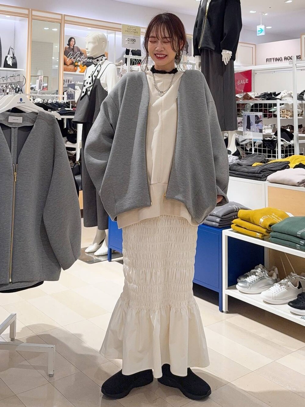 ブラック系のスカート、ベージュ系のシャツ/ブラウス、ブラック系のローファーを着用したレディースの秋コーディネートの4枚目の写真