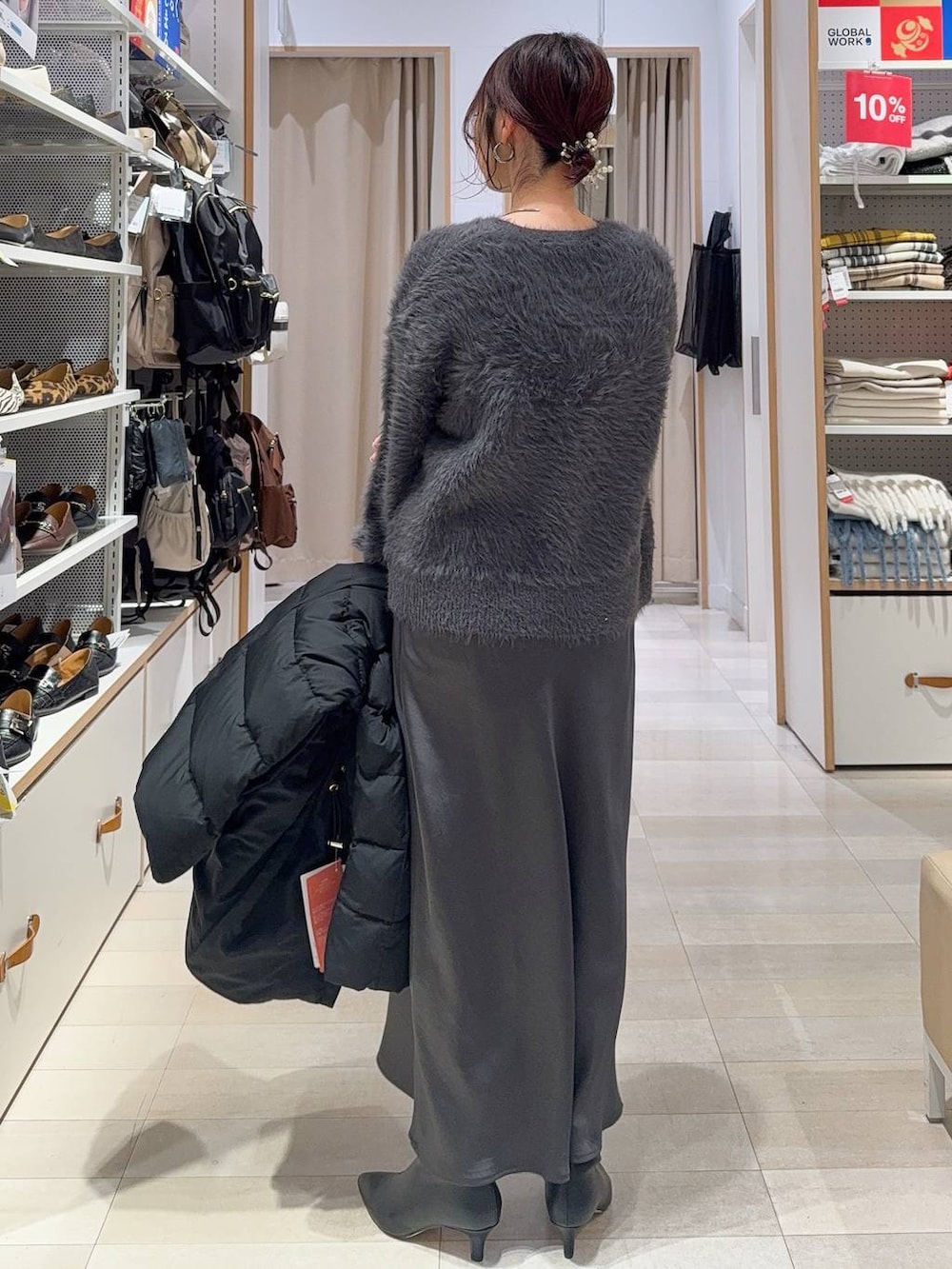 シルバー系のショルダーバッグ、ベージュ系のダウンジャケット/コート、グレー系のニット/セーターを着用したレディースの冬コーディネートの9枚目の写真