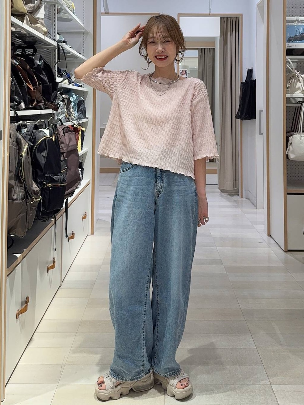 ブルー系のデニムパンツ、ホワイト系のその他トップス、シルバー系のネックレスを着用したレディースの春コーディネートの4枚目の写真